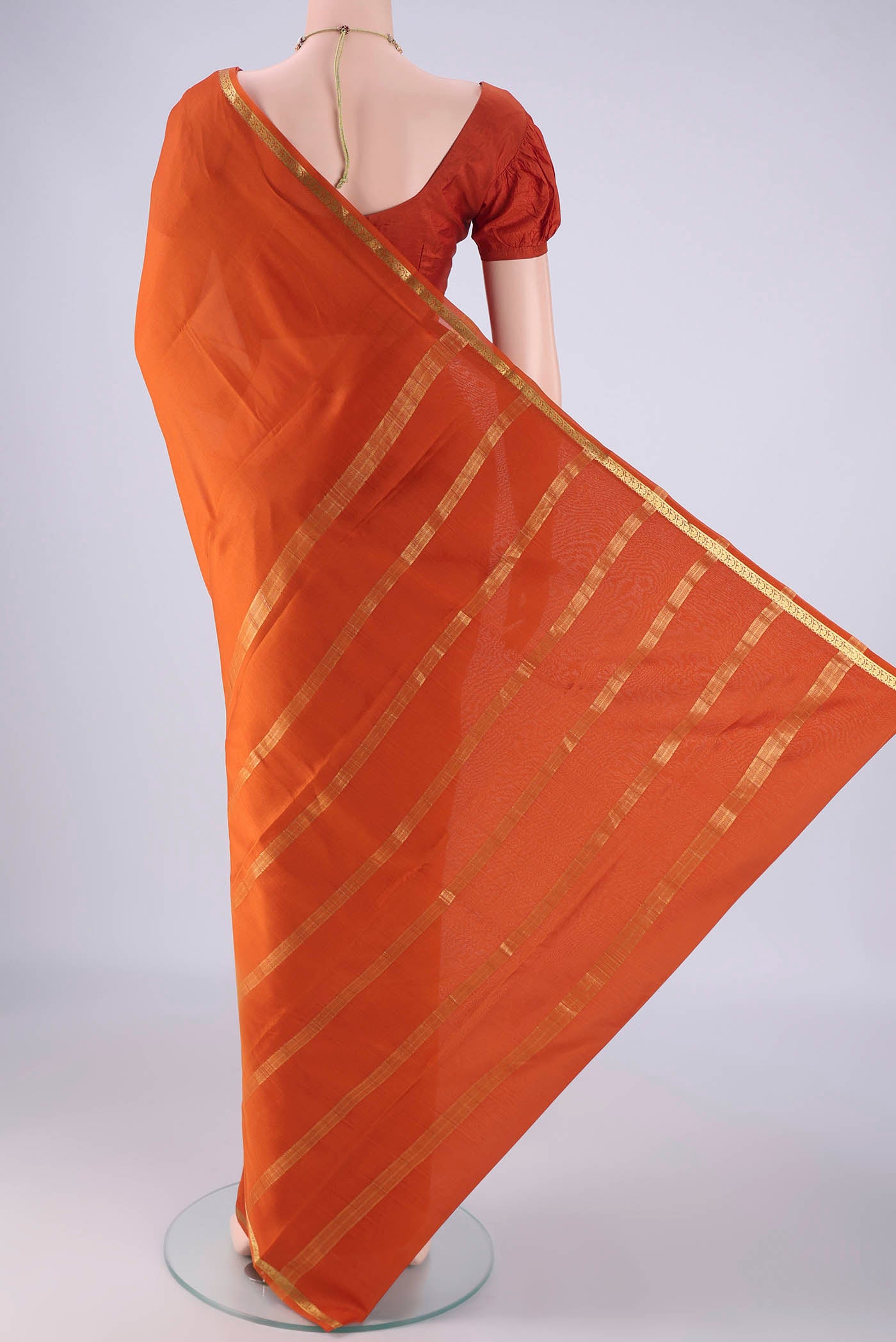 Flat view of Rust Mysore Crepe Saree with Plain Body and Zari Border. 