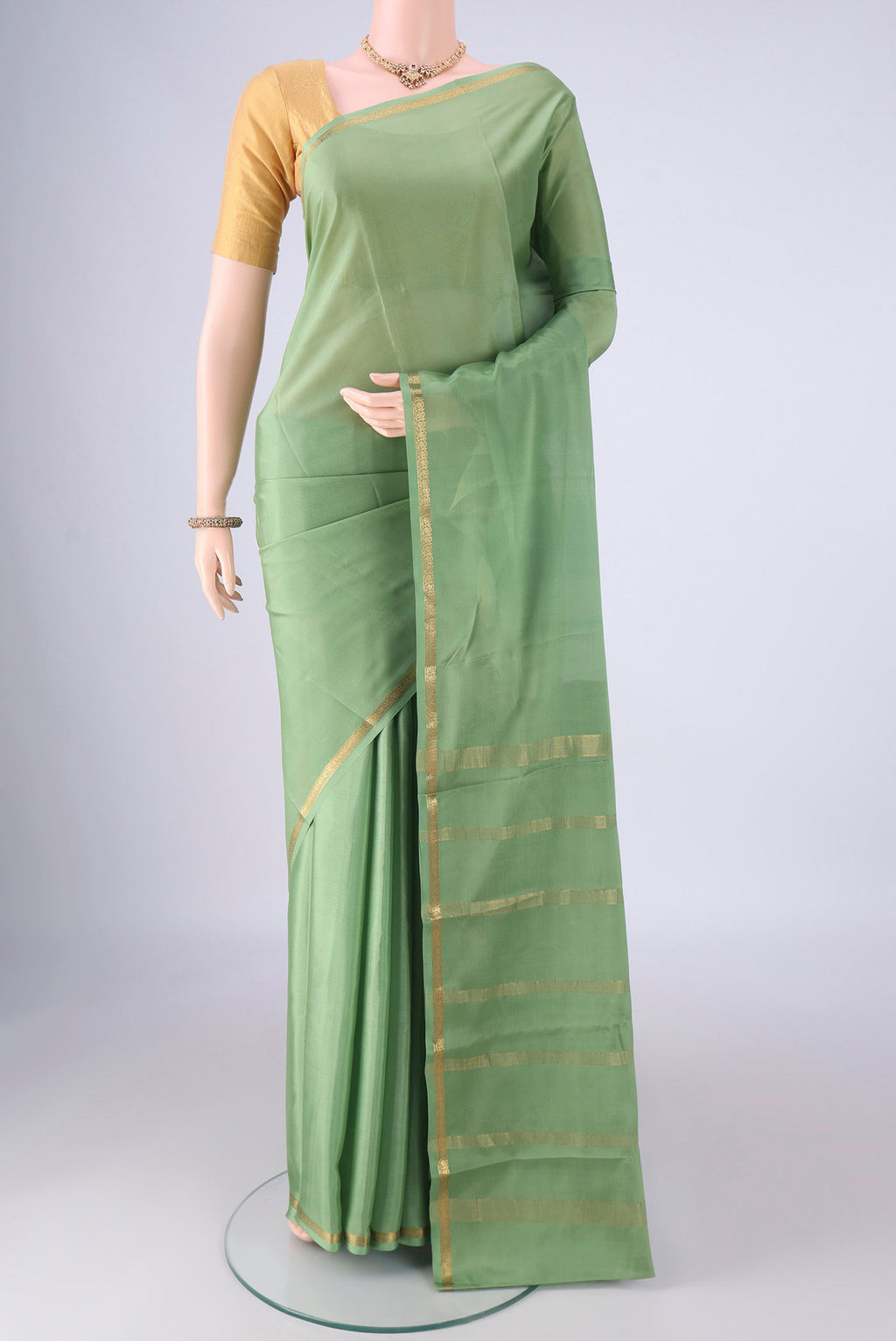 Sage Green Mysore Crepe Saree with Plain Body and Zari Border.  displayed on a mannequin