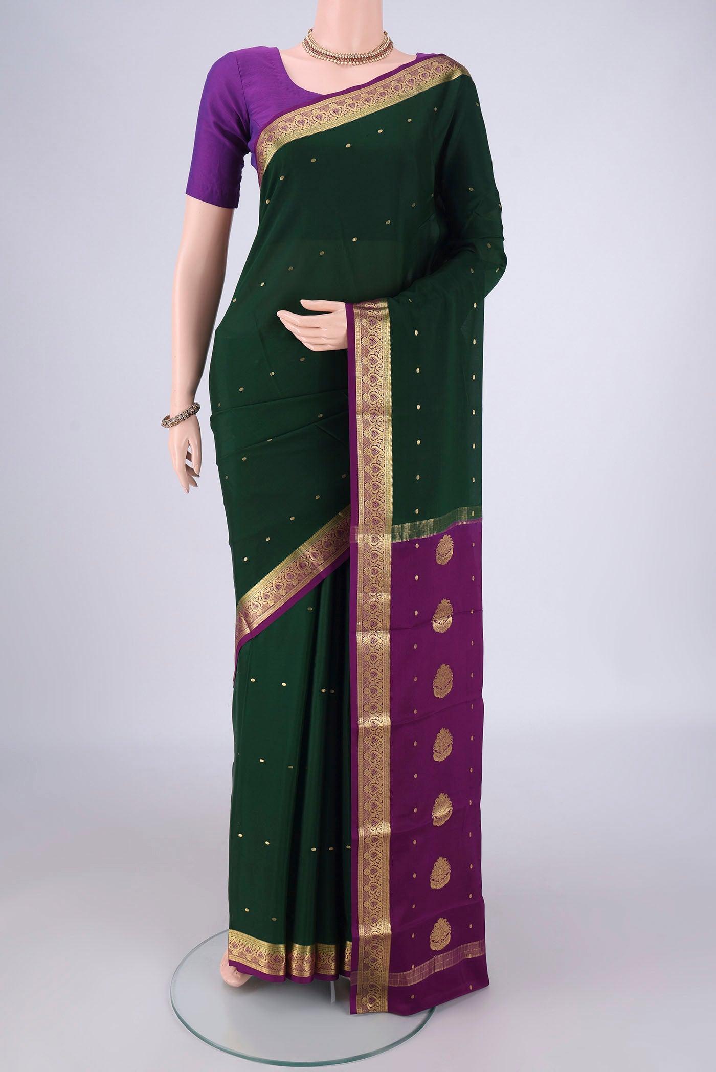 Bottle Green Mysore Crepe Saree with Zari Butta on the body and Zari Border.  displayed on a mannequin