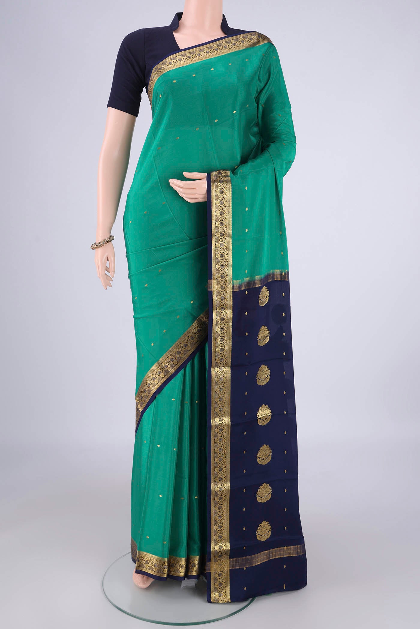 Sea Green Mysore Crepe Saree with Zari Butta on the body and Zari Border.  displayed on a mannequin
