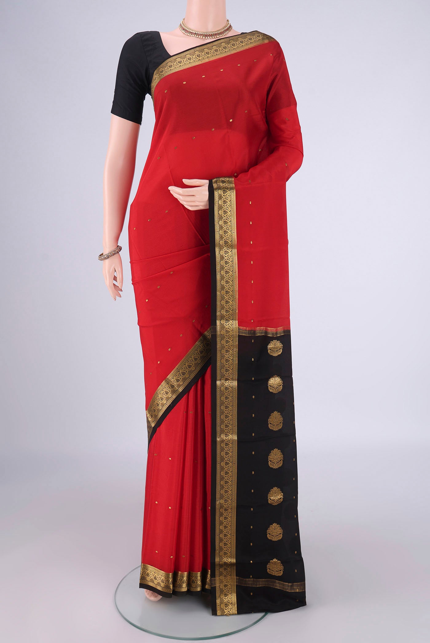 Red Mysore Crepe Saree with Zari Butta on the body and Zari Border.  displayed on a mannequin