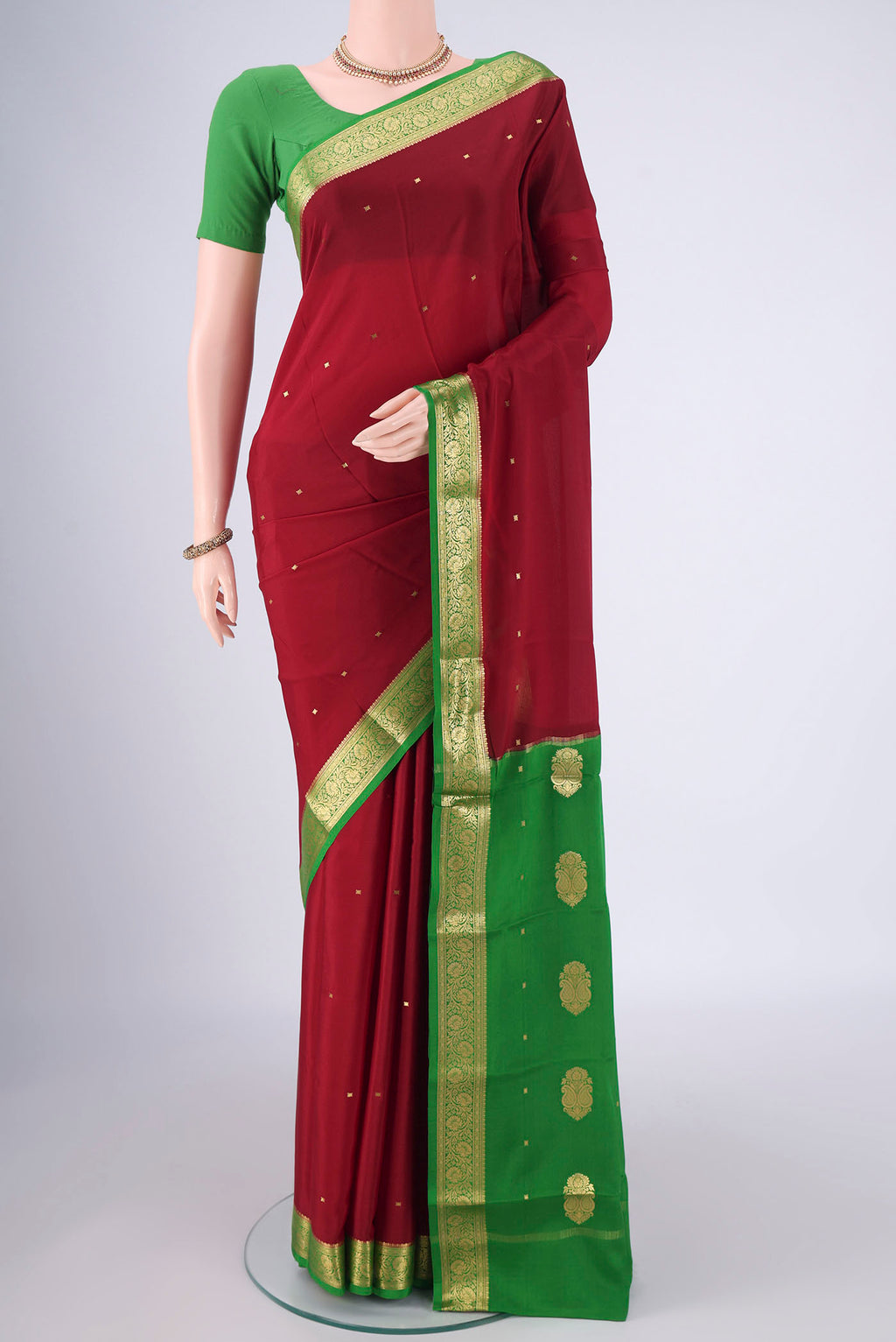 Maroon Mysore Crepe Saree with Zari Butta on the body and Zari Border.  displayed on a mannequin