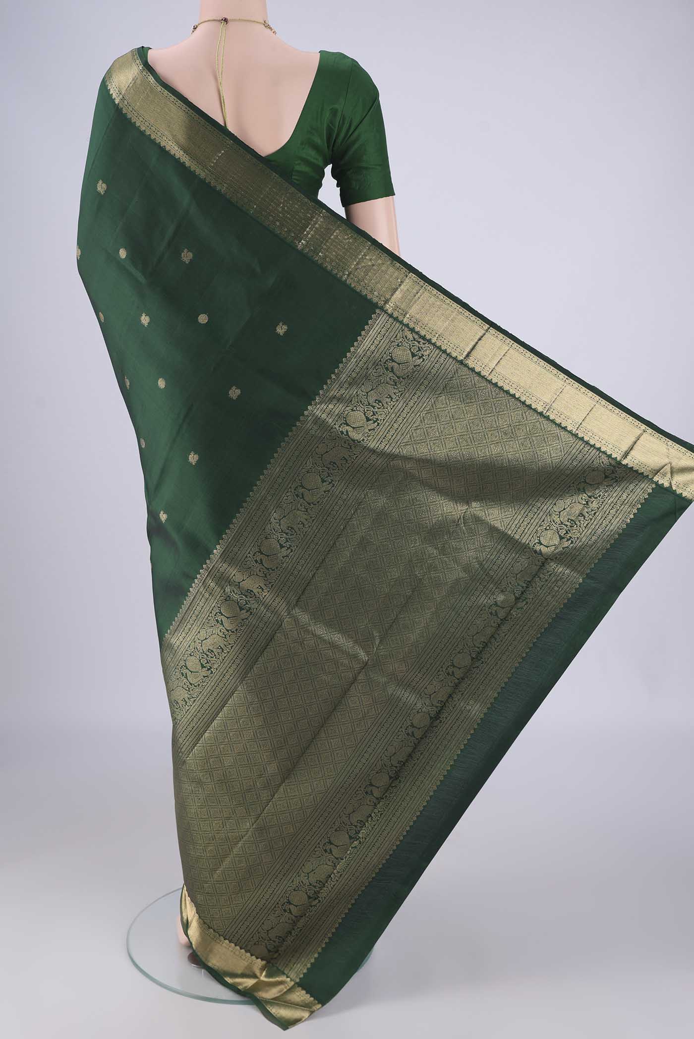 Flat view of Bottle Green Kanjivaram Silk Saree with Zari Butta on the body and Zari Border. 