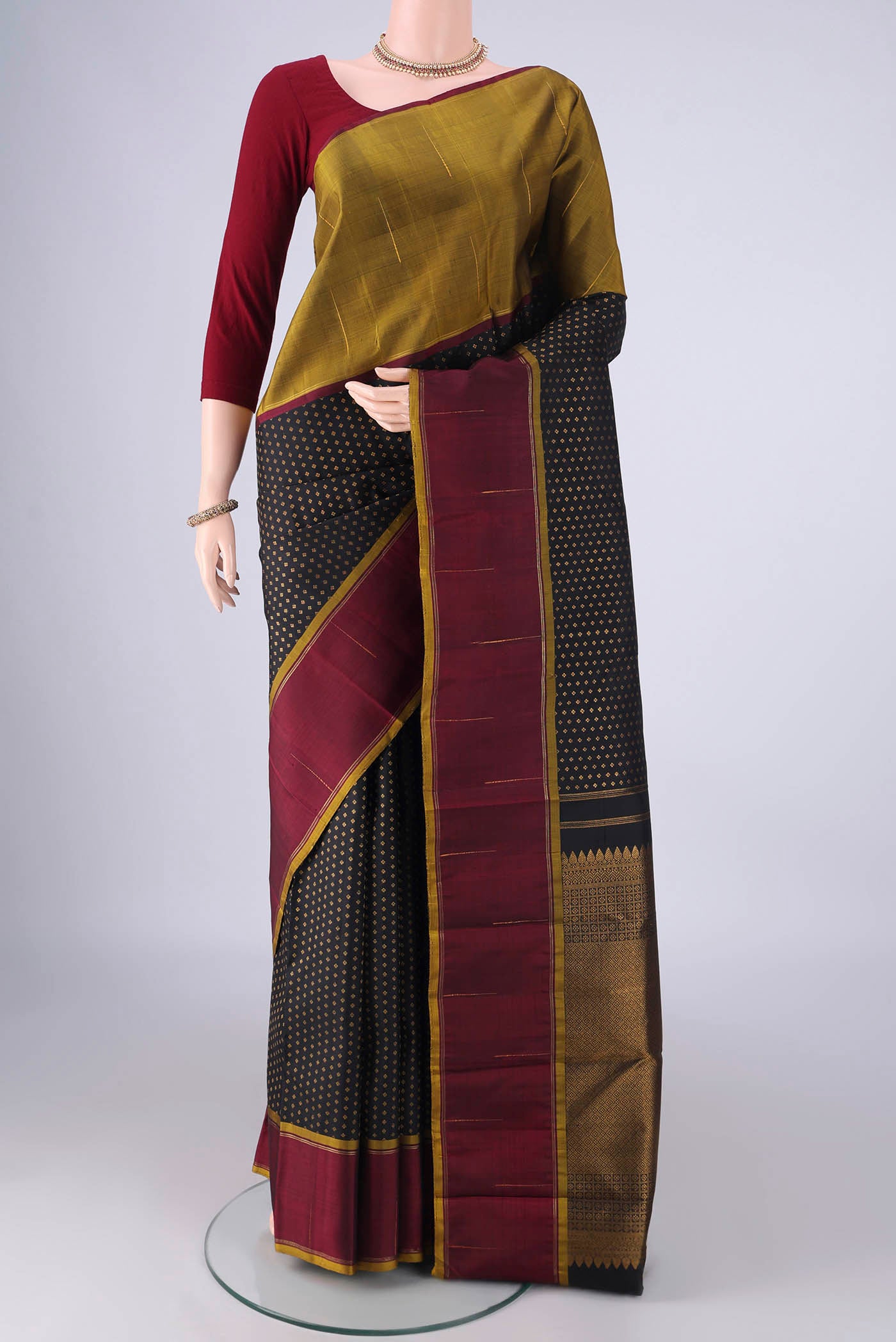 Black Kanjivaram Silk Saree with Zari Butta on the body and Ganga Jamuna Border.  displayed on a mannequin