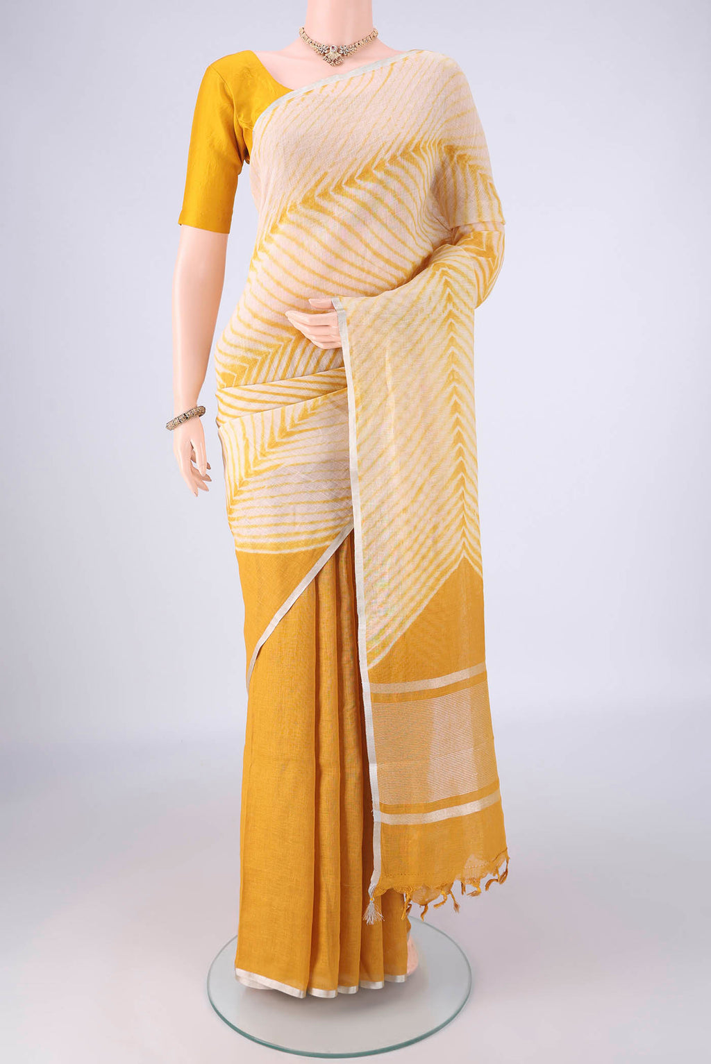 Beige Linen Saree with Printed design on the body and Thin Zari Line.  displayed on a mannequin