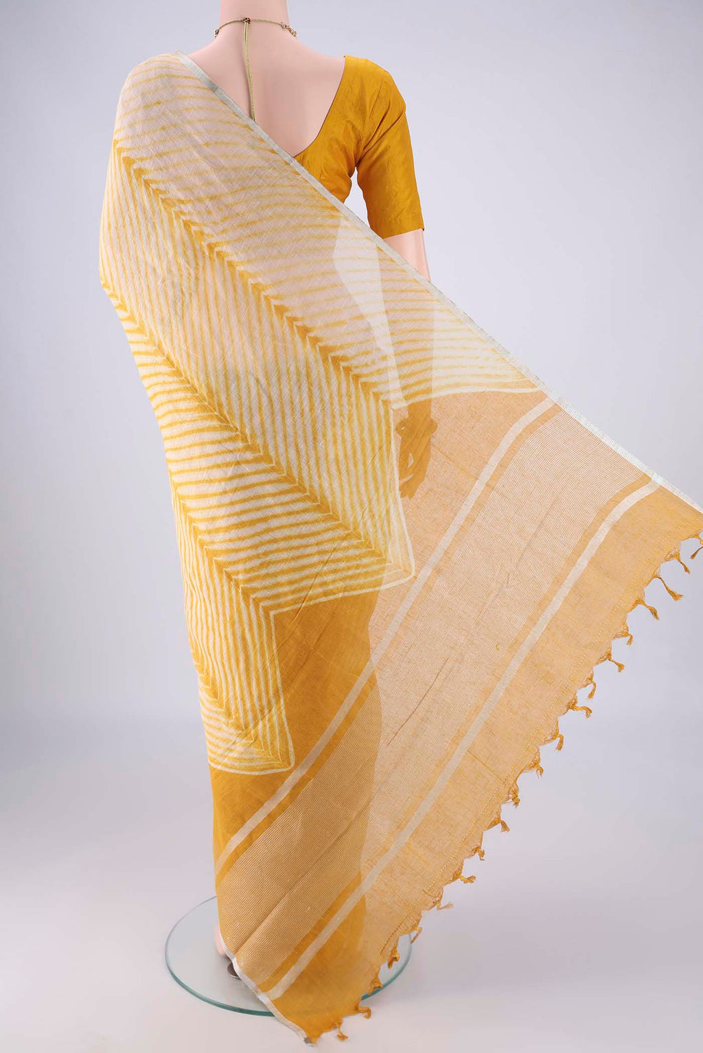 Flat view of Beige Linen Saree with Printed design on the body and Thin Zari Line. 