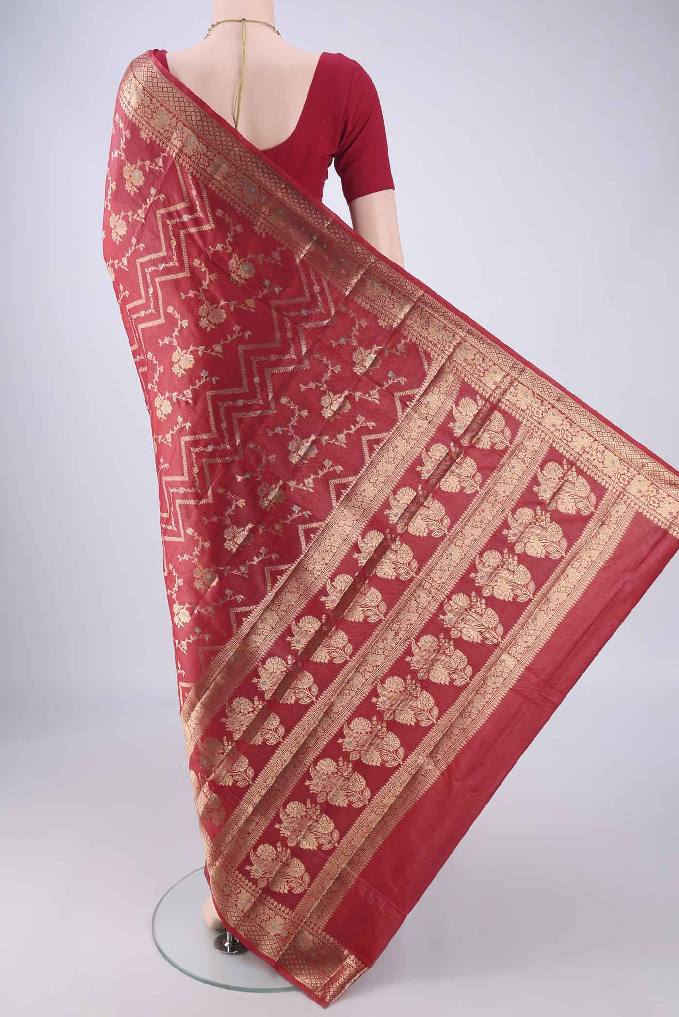 Flat view of Red Banarasi Tussar Silk Saree with Zari And Thread Butta on the body and Zari Border. 