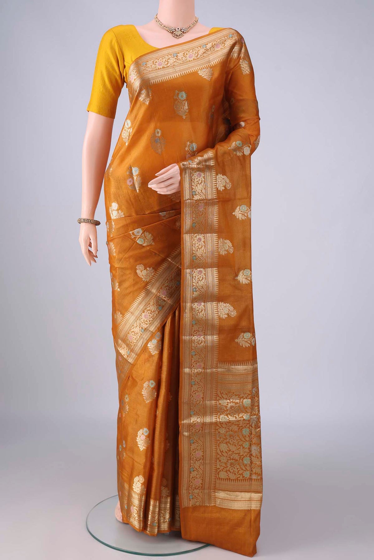 Mustard Banarasi Tussar Saree with Zari And Thread Butta on the body and Zari Border.  displayed on a mannequin