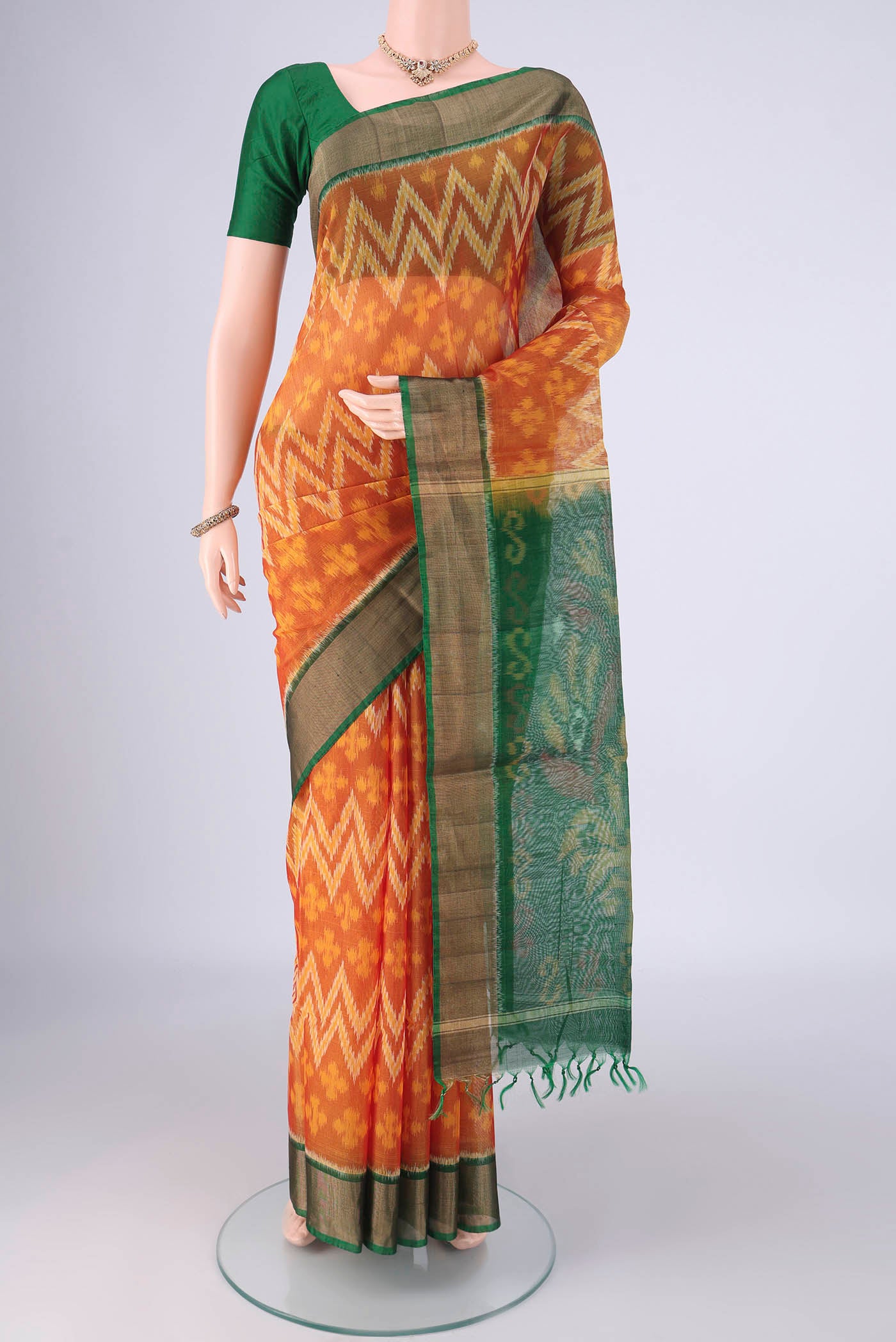 Mustard Silk Cotton Saree with Ikat design on the body and Zari Border.  displayed on a mannequin