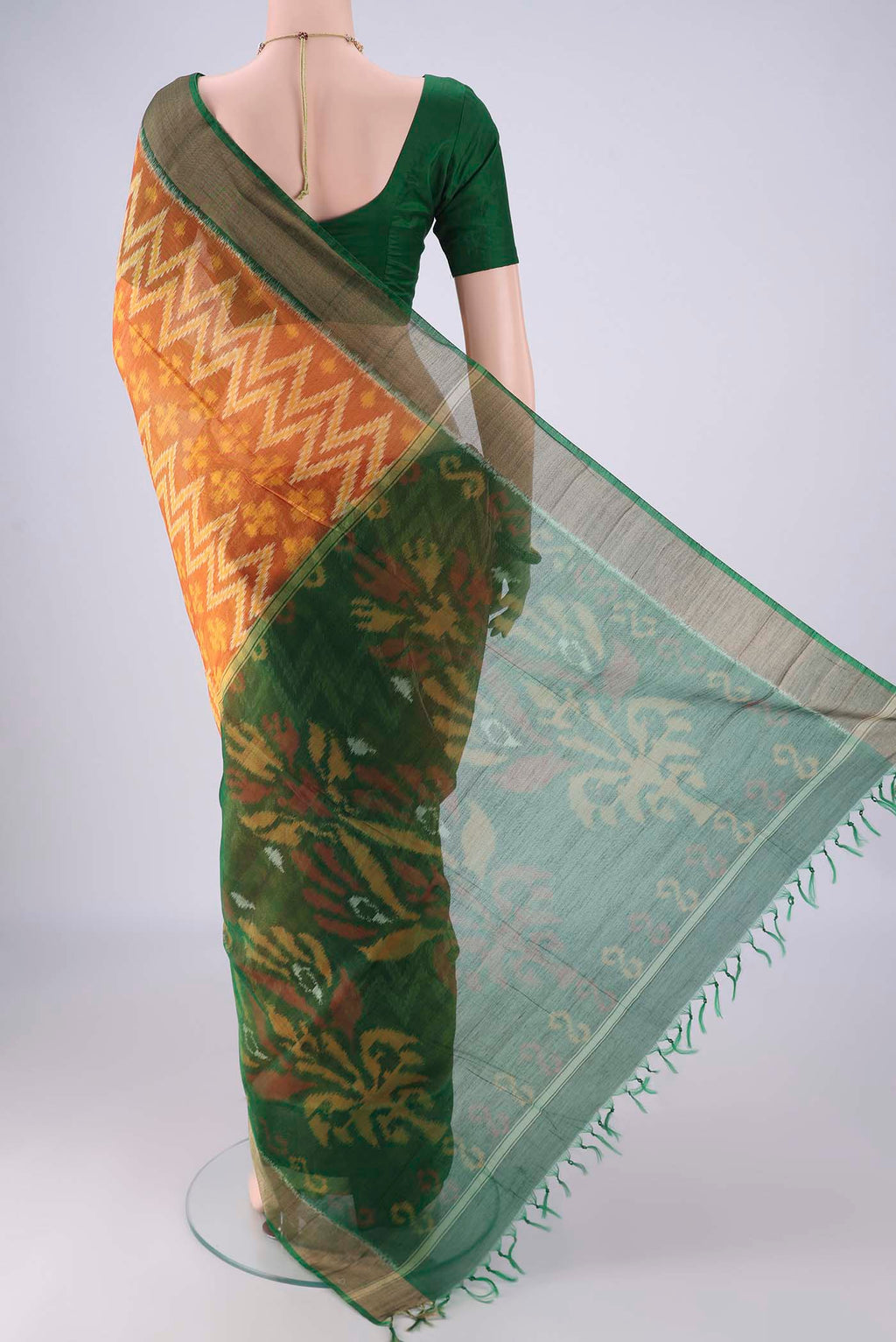 Flat view of Mustard Silk Cotton Saree with Ikat design on the body and Zari Border. 