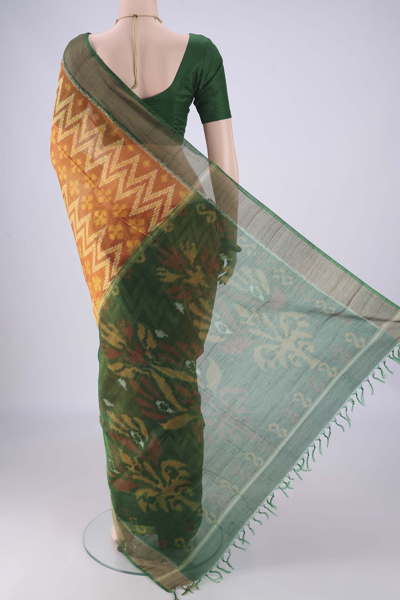 Flat view of Mustard Silk Cotton Saree with Ikat design on the body and Zari Border. 