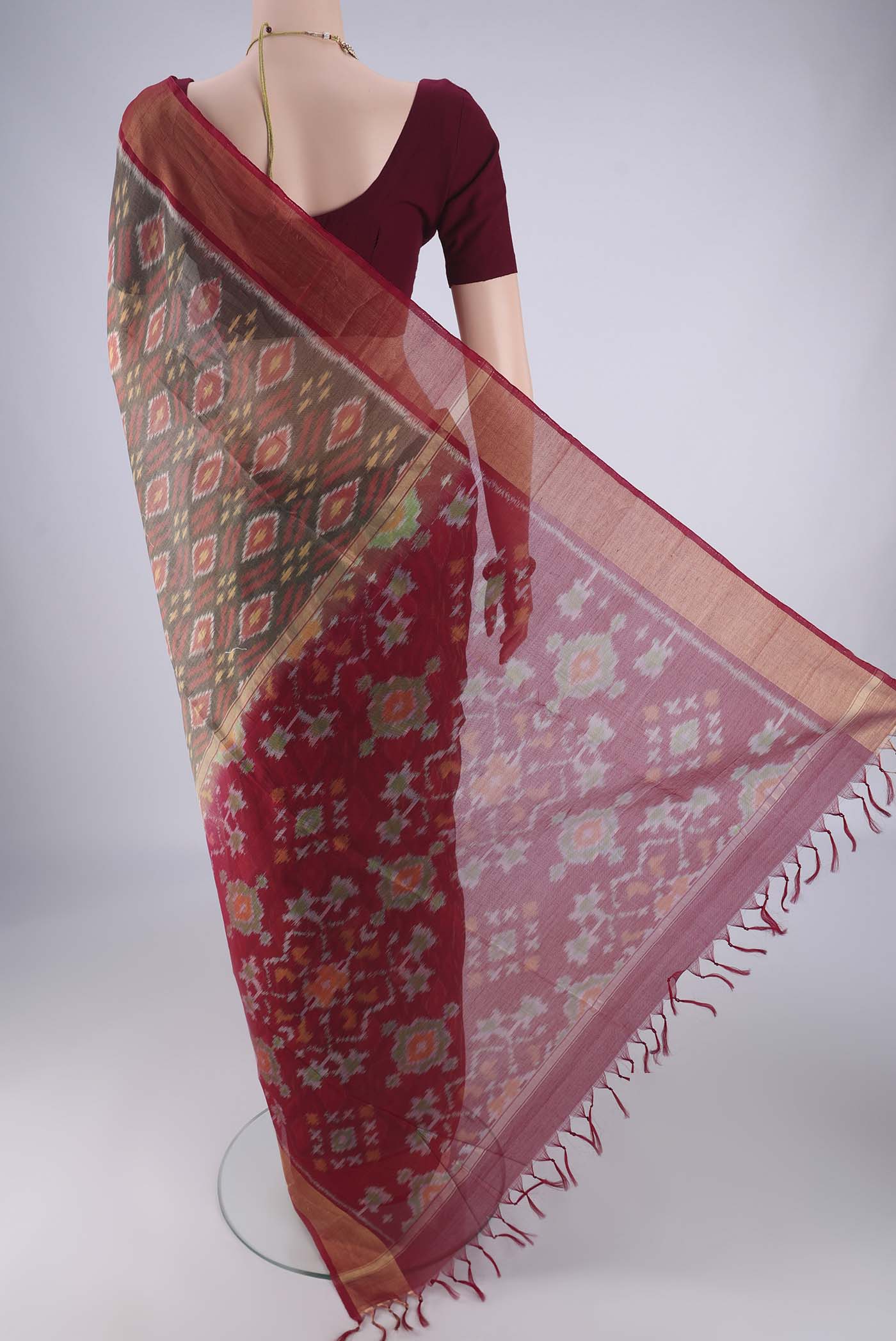 Flat view of Grey Silk Cotton Saree with Ikat design on the body and Zari Border. 