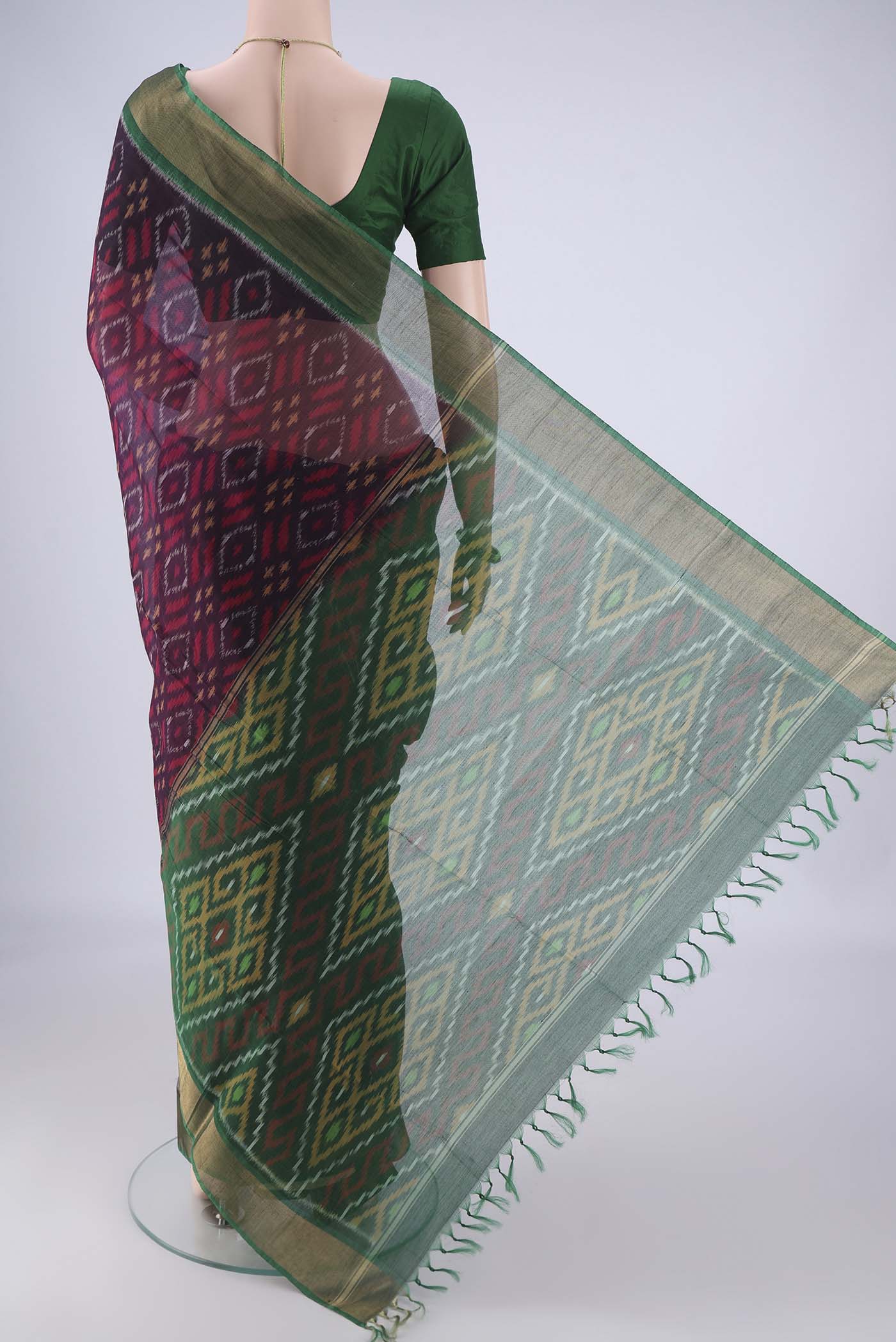 Flat view of Purple Silk Cotton Saree with Ikat design on the body and Zari Border. 