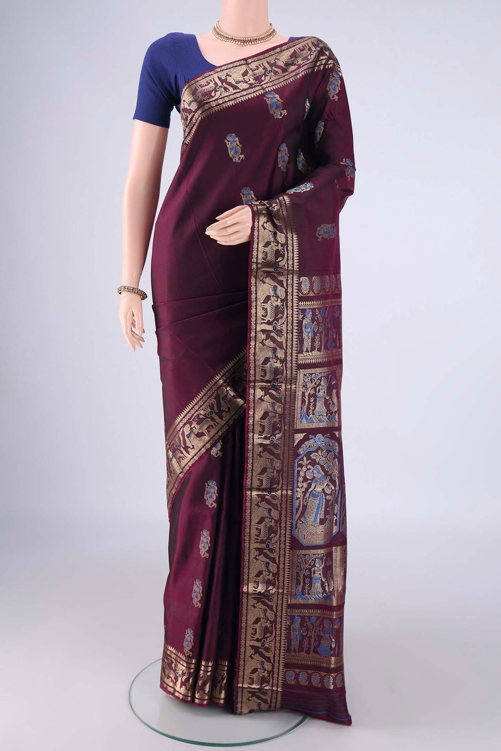 Burgundy Baluchari Silk Saree with Zari And Thread Butta on the body and Zari And Thread Border.  displayed on a mannequin