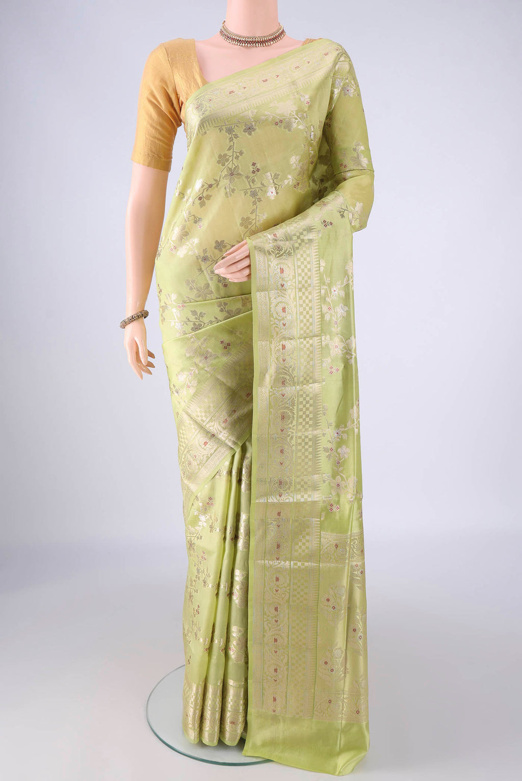 Pista Green Banarasi Raw Silk Saree with Zari And Thread Butta on the body and Zari Border.  displayed on a mannequin