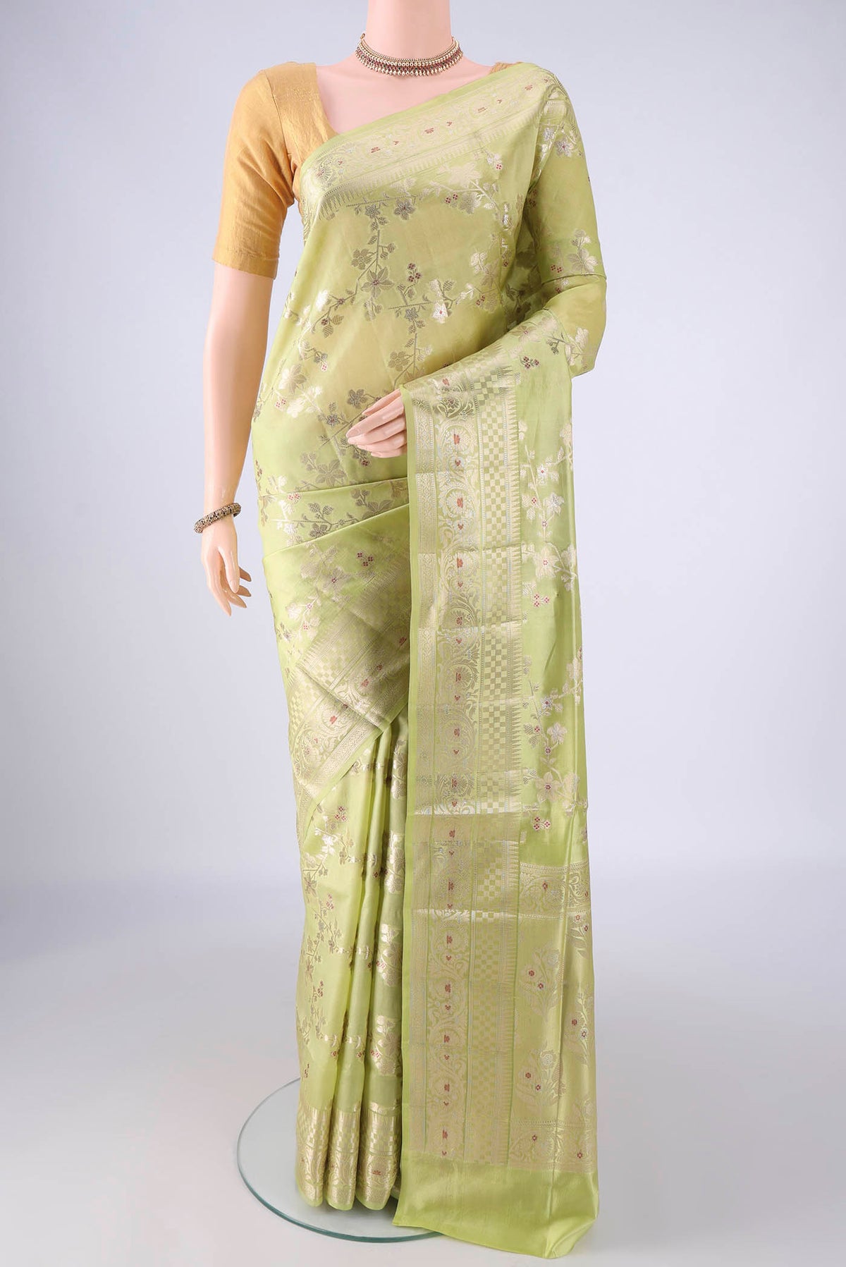 Pista Green Banarasi Raw Silk Saree with Zari And Thread Butta on the body and Zari Border.  displayed on a mannequin