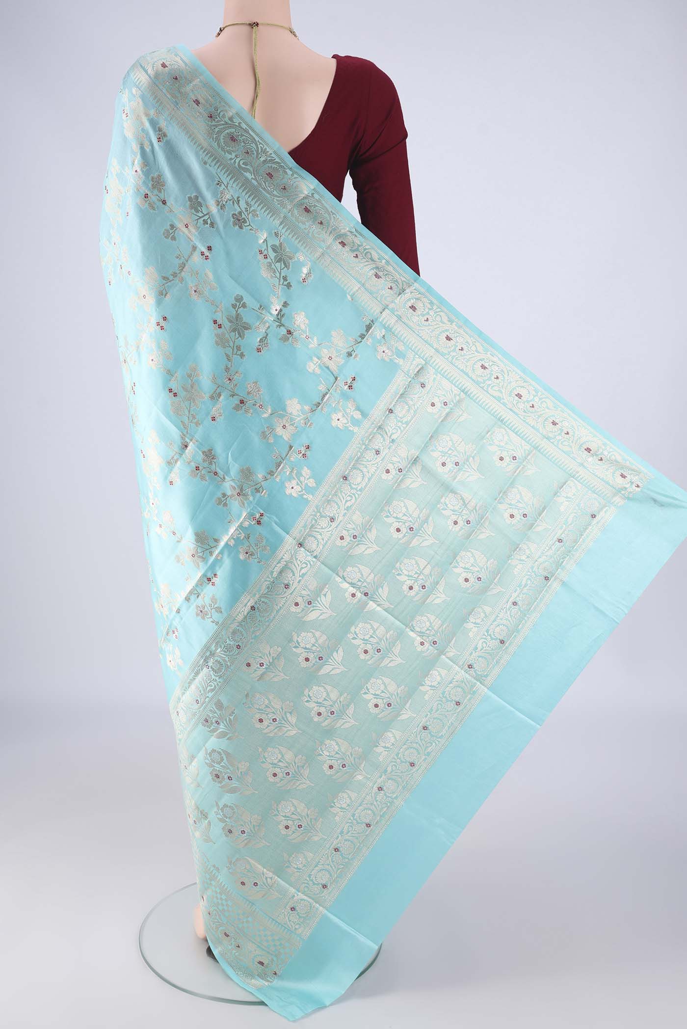 Flat view of Sky Blue Banarasi Raw Silk Saree with Zari And Thread Butta on the body and Zari And Thread Border. 