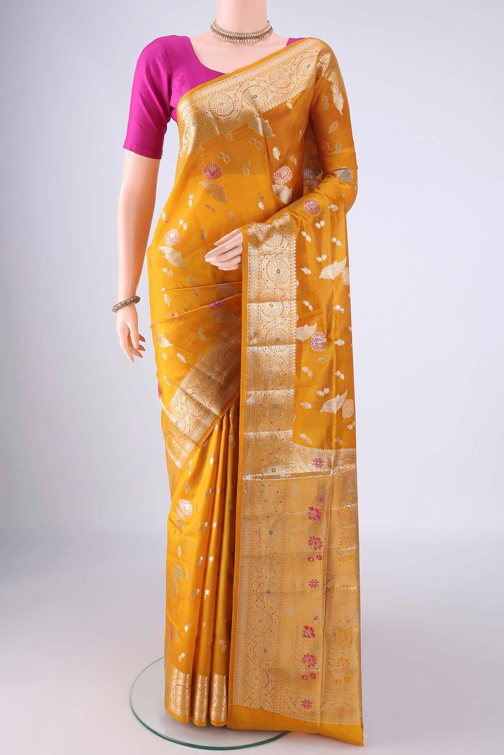 Mustard Banarasi Raw Silk Saree with Zari And Thread Butta on the body and Zari Border.  displayed on a mannequin