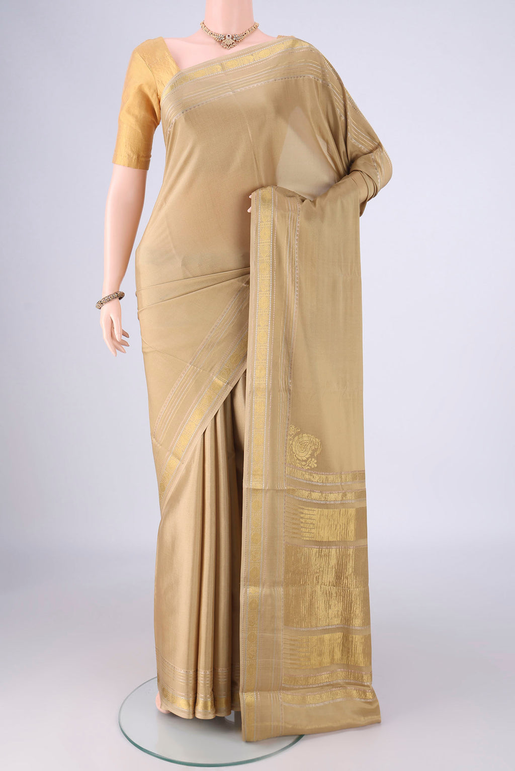 Beige Mysore Crepe Saree with Plain Body and Zari Border.  displayed on a mannequin