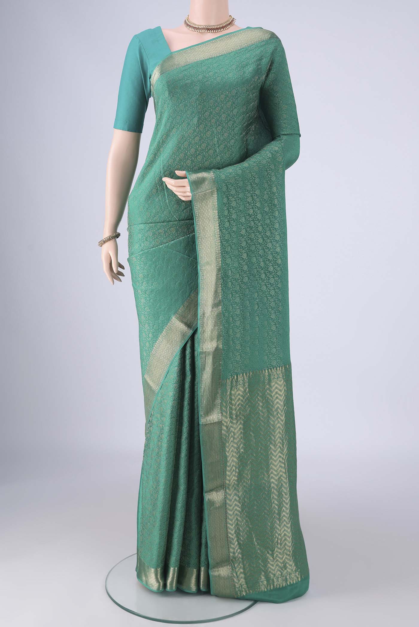 Turquoise Mysore Crepe Saree with Zari Brocade on the body and Zari Border.  displayed on a mannequin