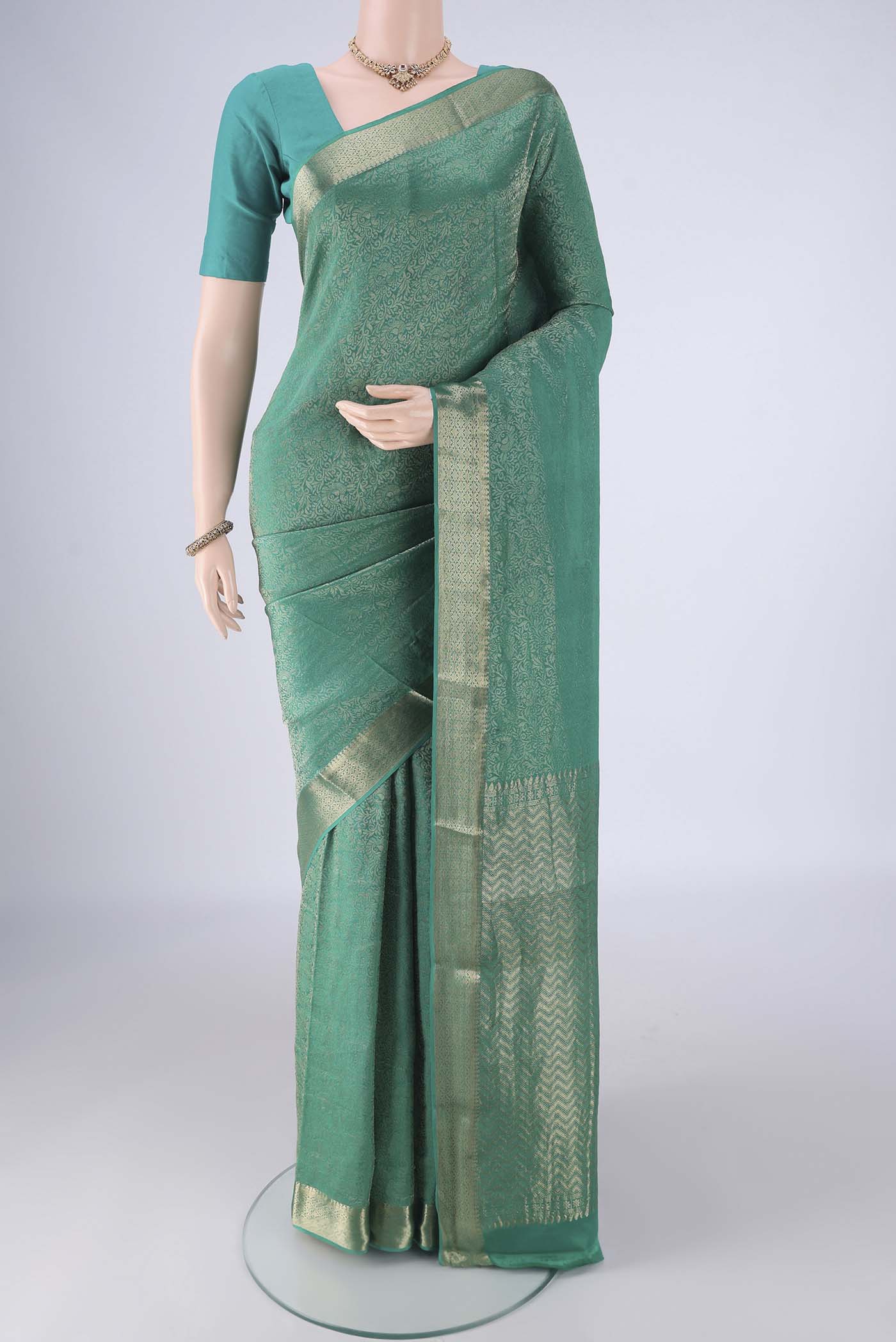 Sea Green Mysore Crepe Saree with Zari Brocade on the body and Zari Border.  displayed on a mannequin