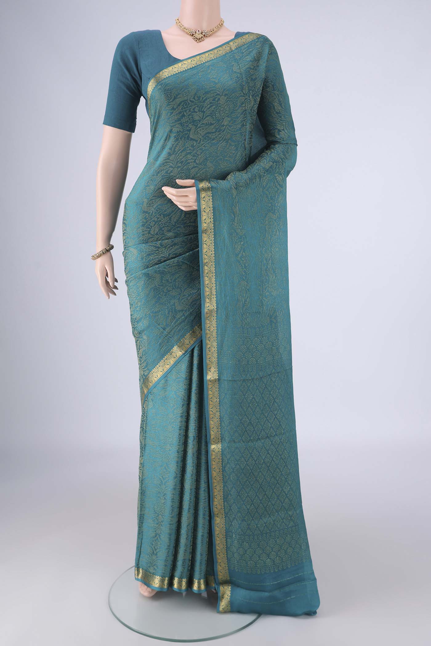 Teal Mysore Crepe Saree with Zari Brocade on the body and Zari Border.  displayed on a mannequin