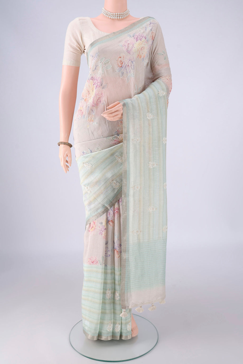 Rose Gold Linen Saree with Embroidery on the body and Zari Border.  displayed on a mannequin