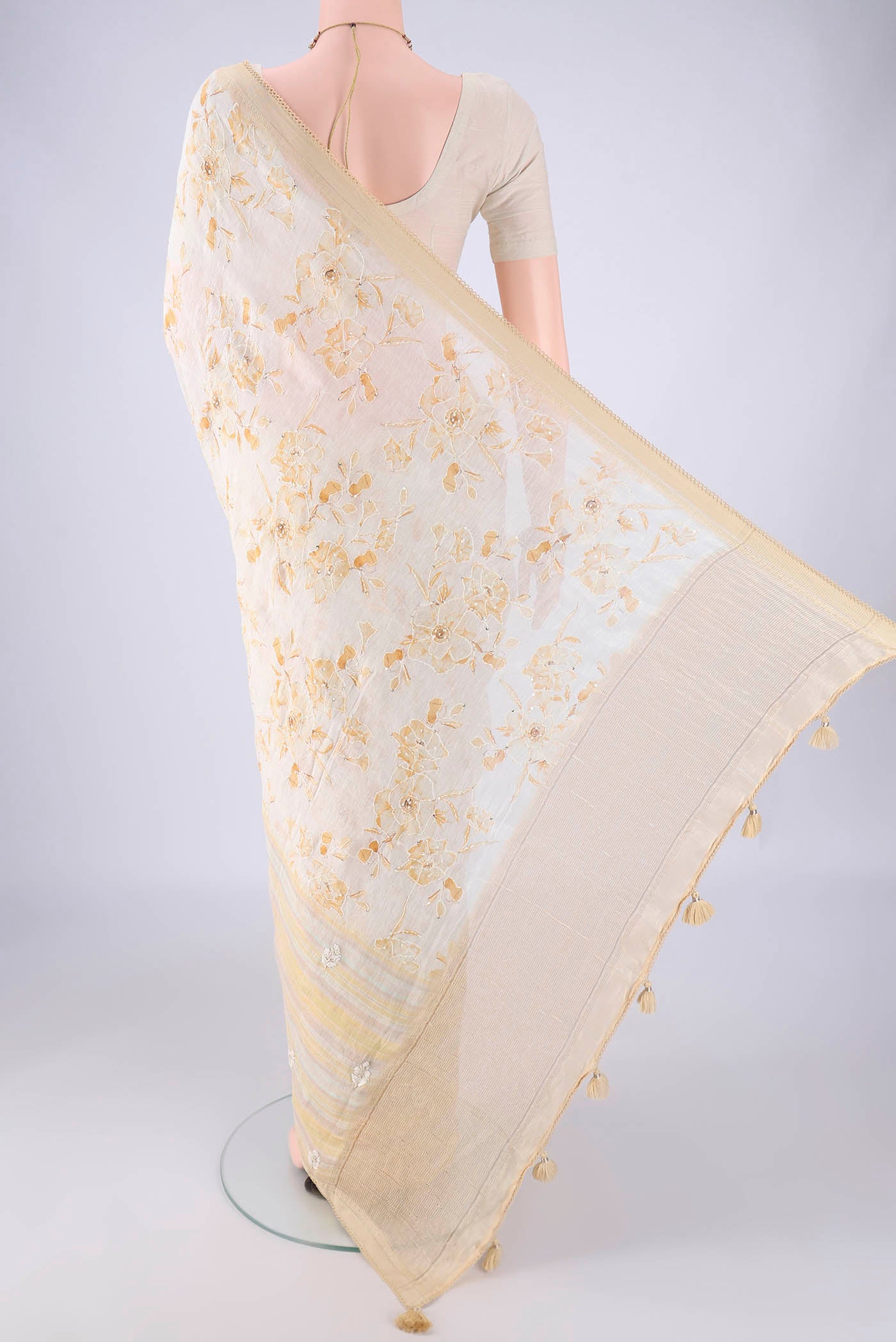 Flat view of Cream Linen Saree with Embroidery on the body and Zari Border. 