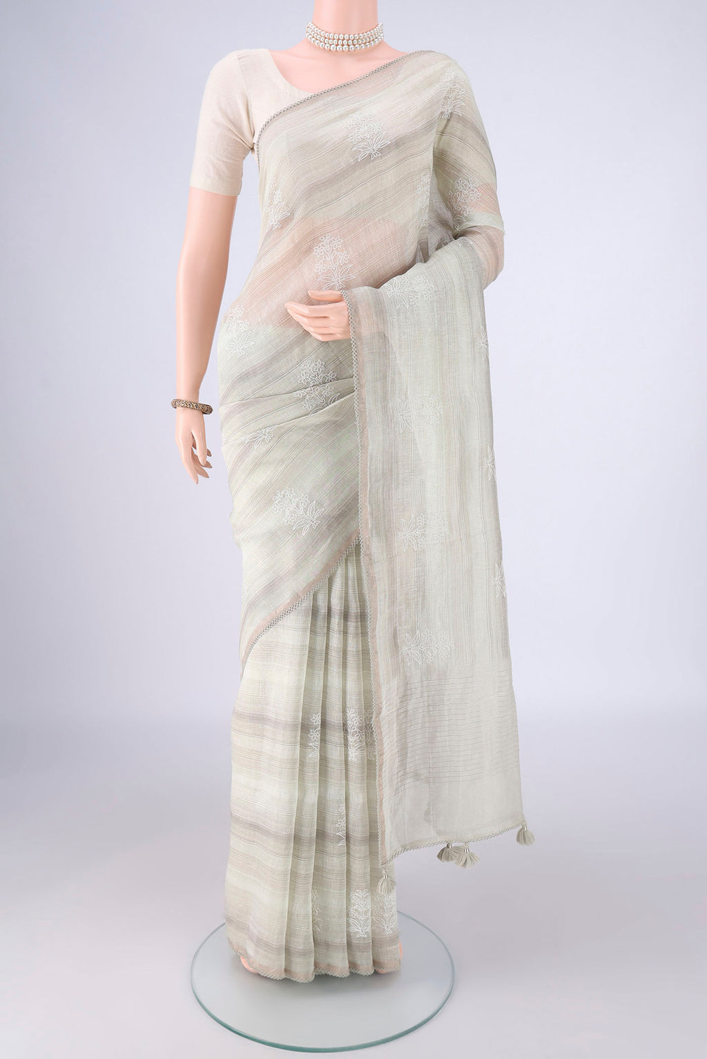 Off White Linen Saree with Embroidery on the body and Thin Zari Line.  displayed on a mannequin