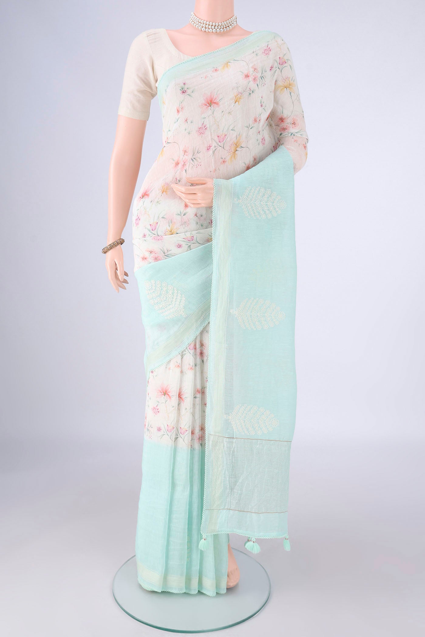 Off White Linen Saree with Printed design on the body and Thin Zari Line.  displayed on a mannequin