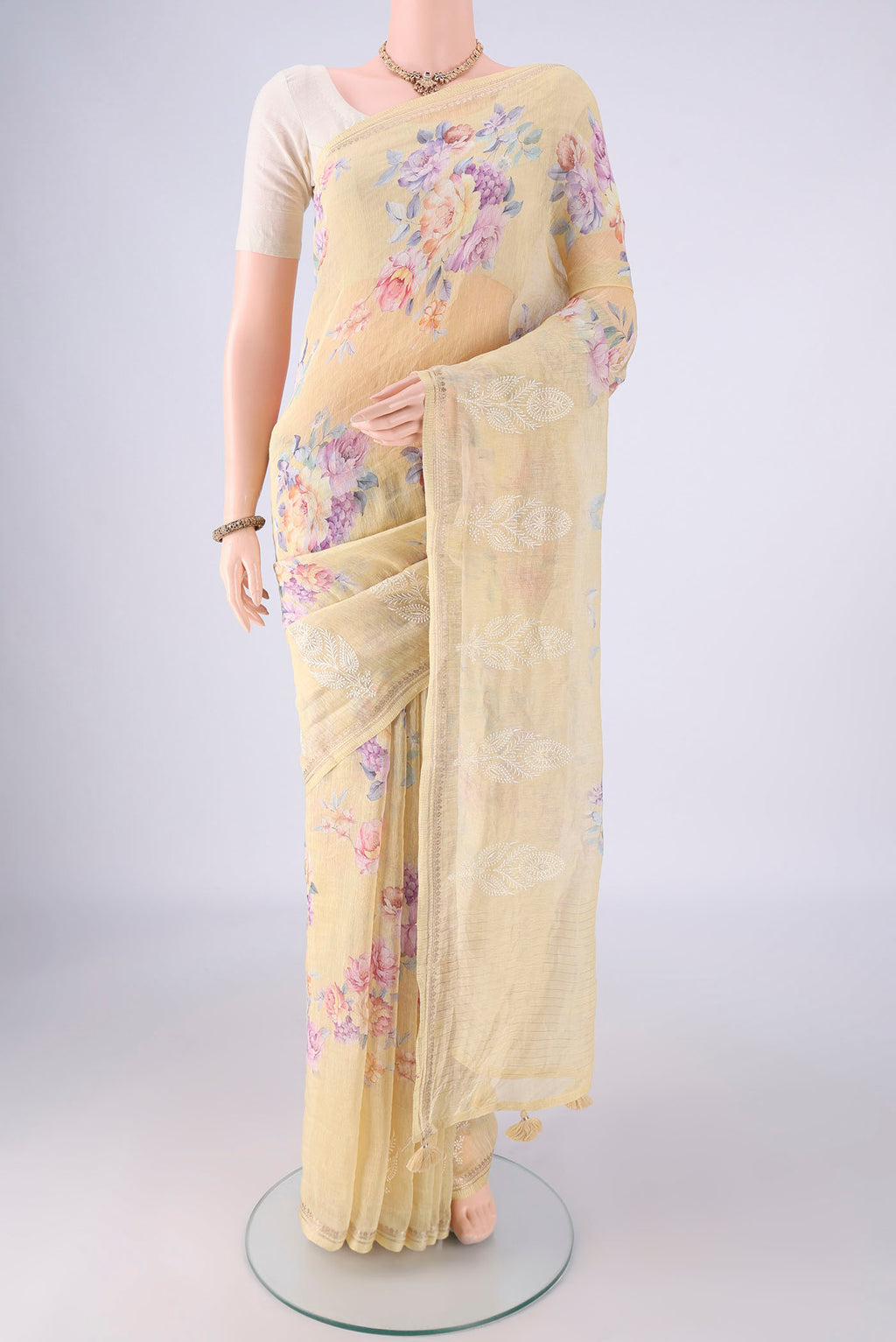 Yellow Linen Saree with Floral Print on the body and Zari Border.  displayed on a mannequin