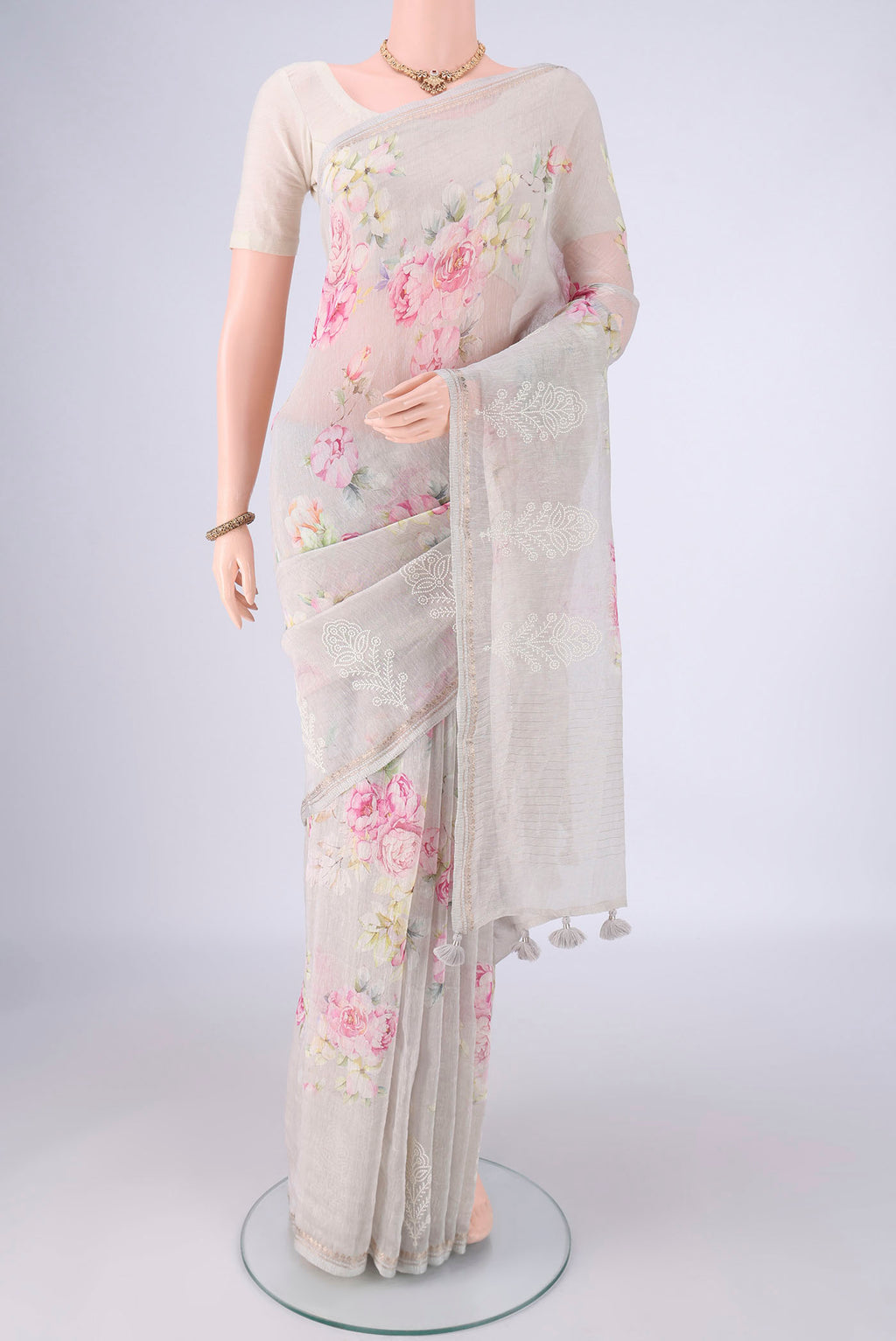 Grey Linen Saree with Floral Print on the body and Zari Border.  displayed on a mannequin