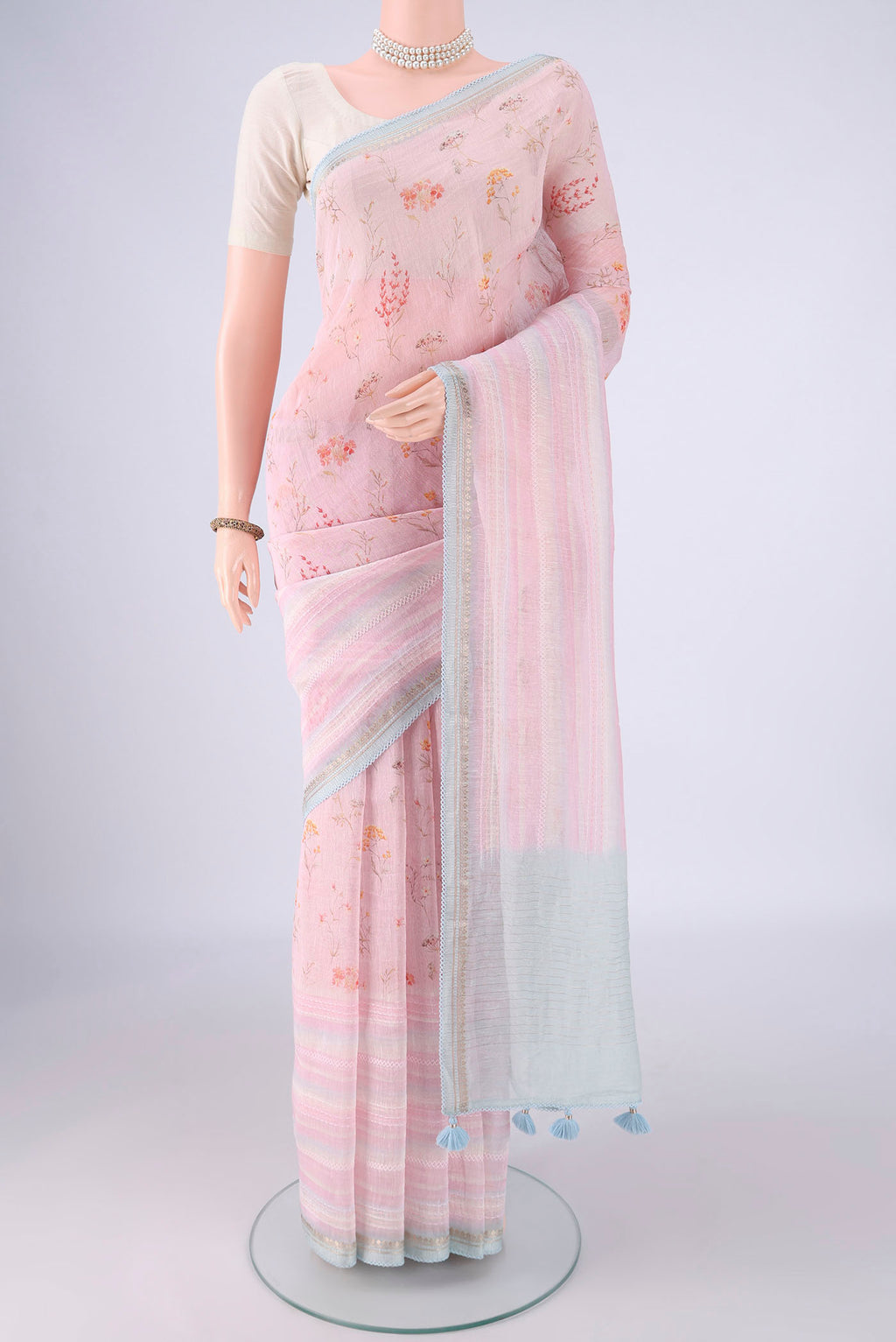 Rose pink Linen Saree with Printed design on the body and Lace Border.  displayed on a mannequin