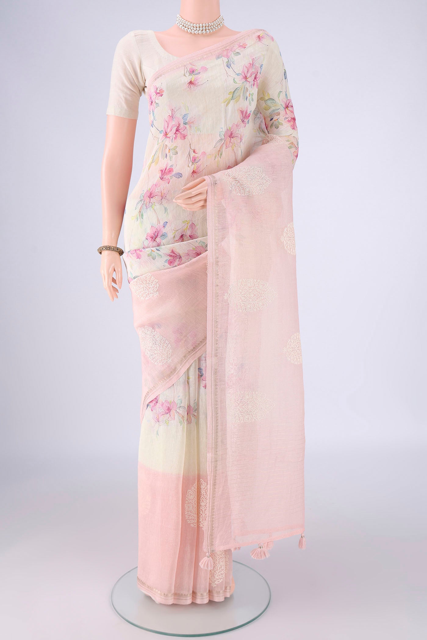 Off White Linen Saree with Floral Print on the body and Lace Border.  displayed on a mannequin