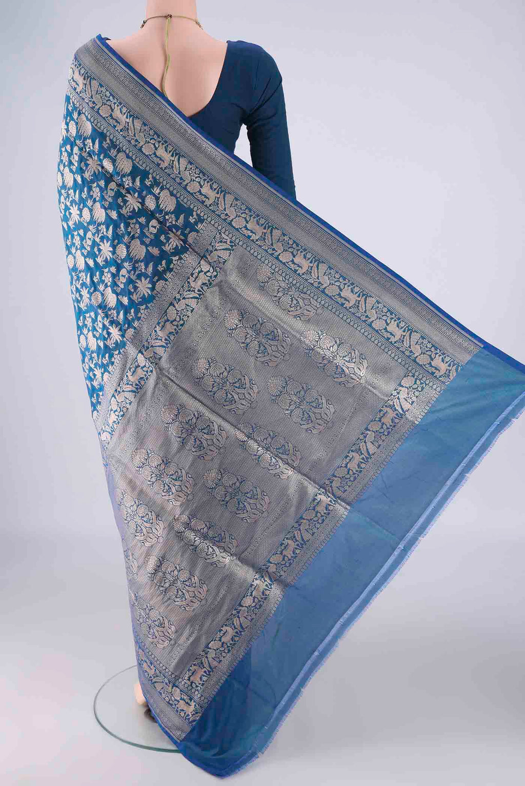 Flat view of Peacock Blue Banarasi Silk Saree with Zari Brocade on the body and Zari Border. 