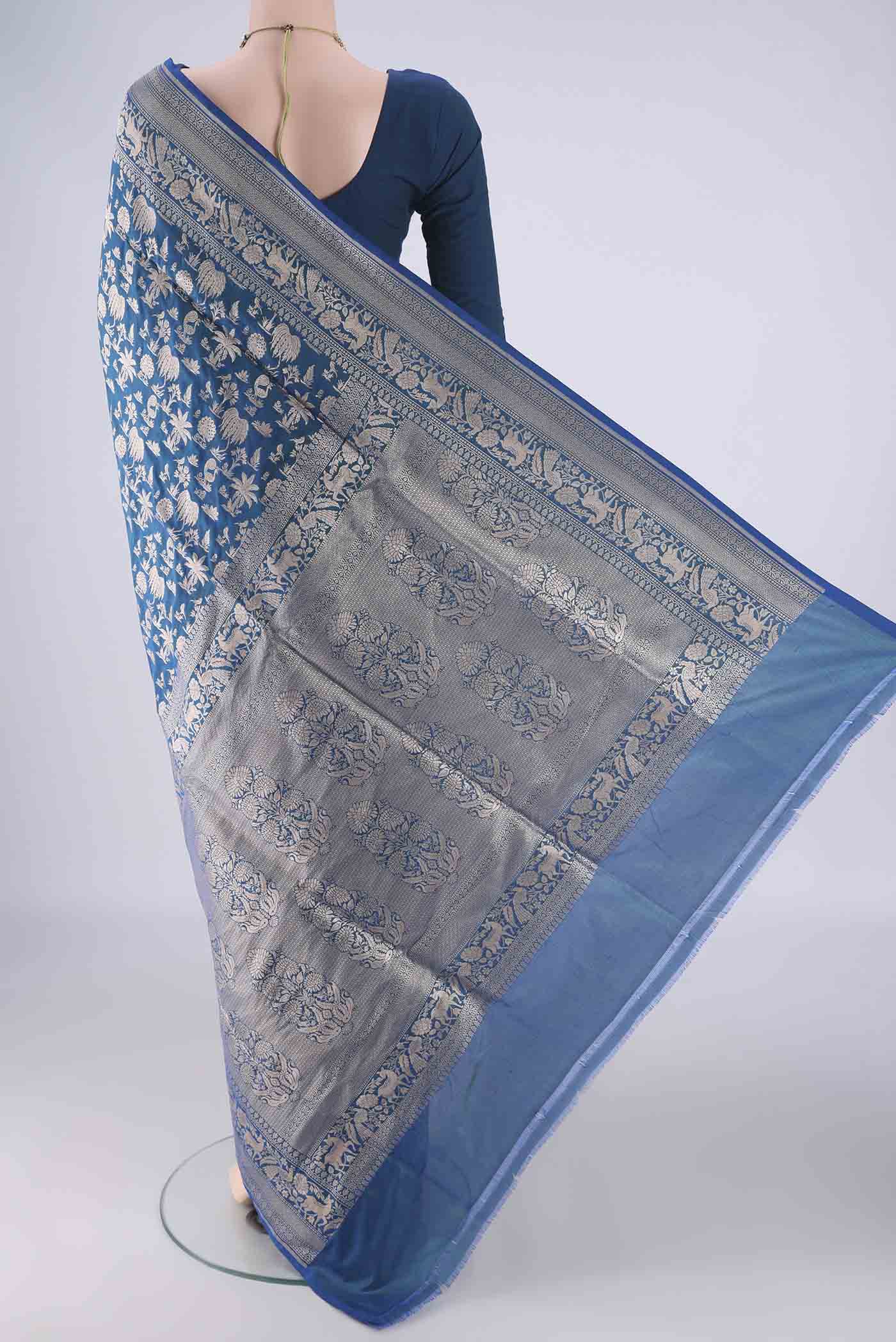 Flat view of Peacock Blue Banarasi Silk Saree with Zari Brocade on the body and Zari Border. 