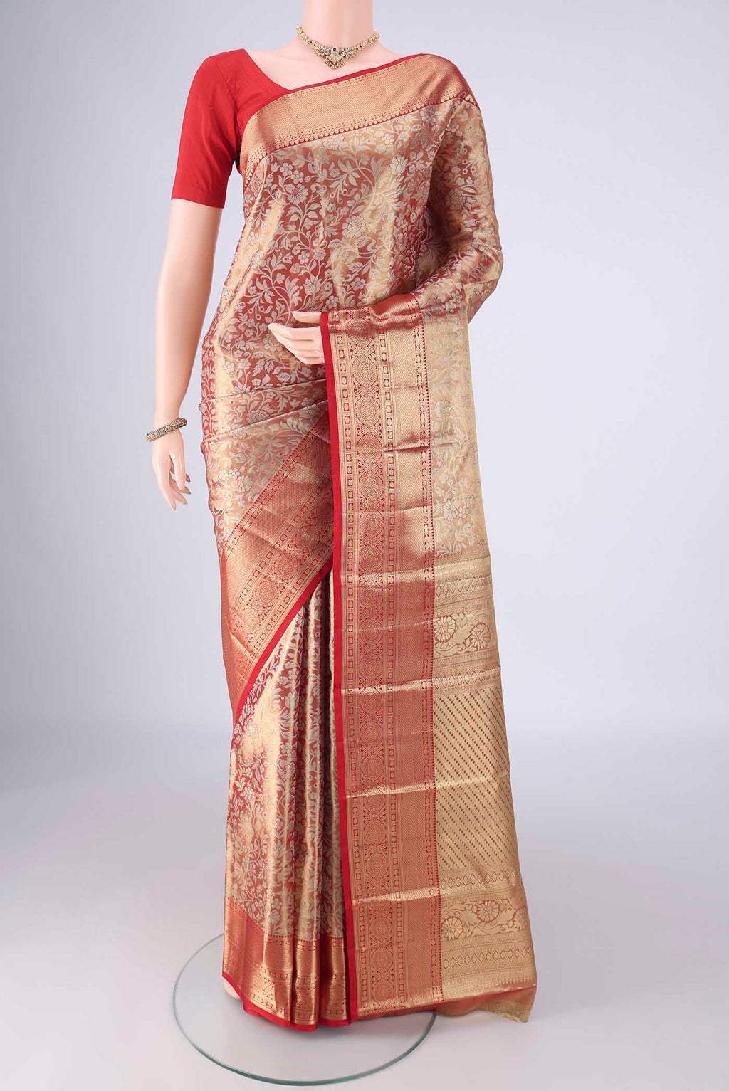 Gold with Red Color Kanjivaram Tissue Silk Saree with Zari Brocade on the body and Zari Border.  displayed on a mannequin