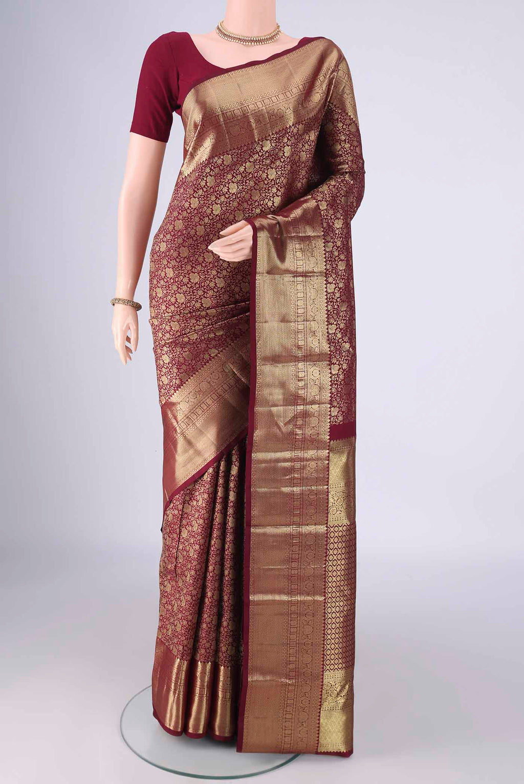 Maroon Kanchipuram Silk Saree with Zari Brocade on the body and Zari Border.  displayed on a mannequin