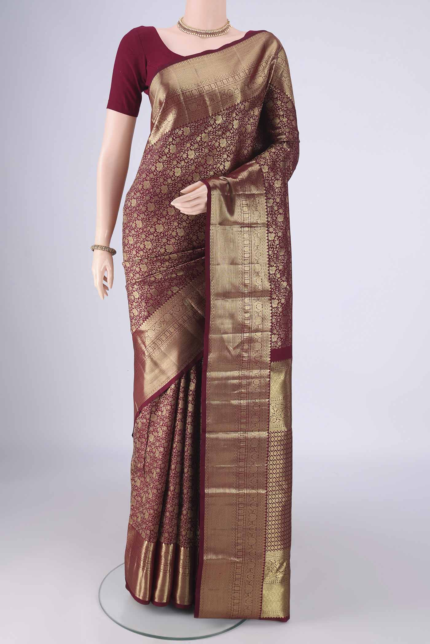 Maroon Kanchipuram Silk Saree with Zari Brocade on the body and Zari Border.  displayed on a mannequin