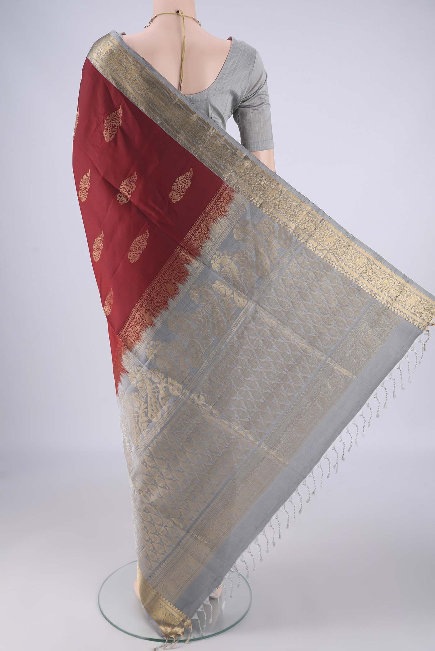 Flat view of Maroon Soft Silk Saree with Zari Butta on the body and Zari Border. 