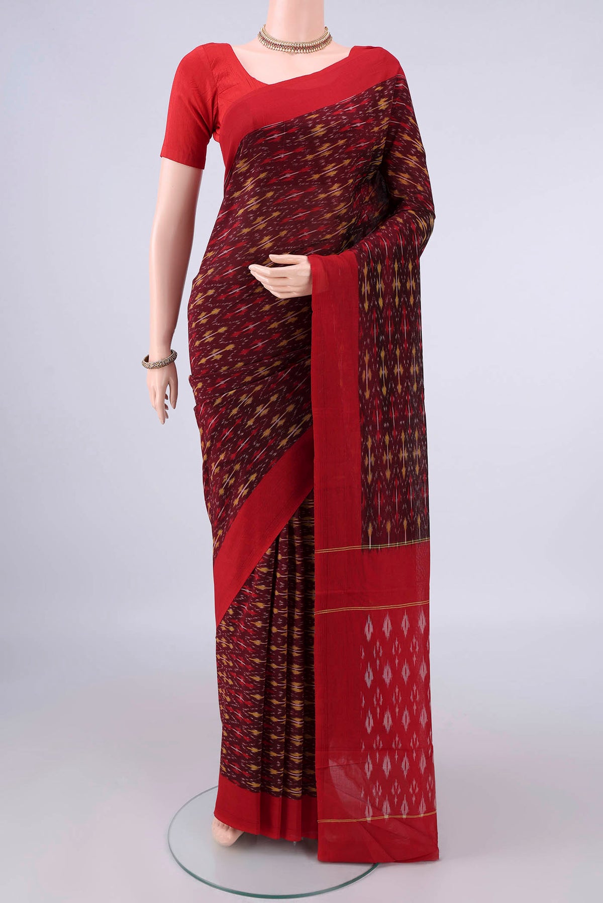 Maroon Pochampally Cotton Saree with Ikat design on the body and Ikat Border.  displayed on a mannequin