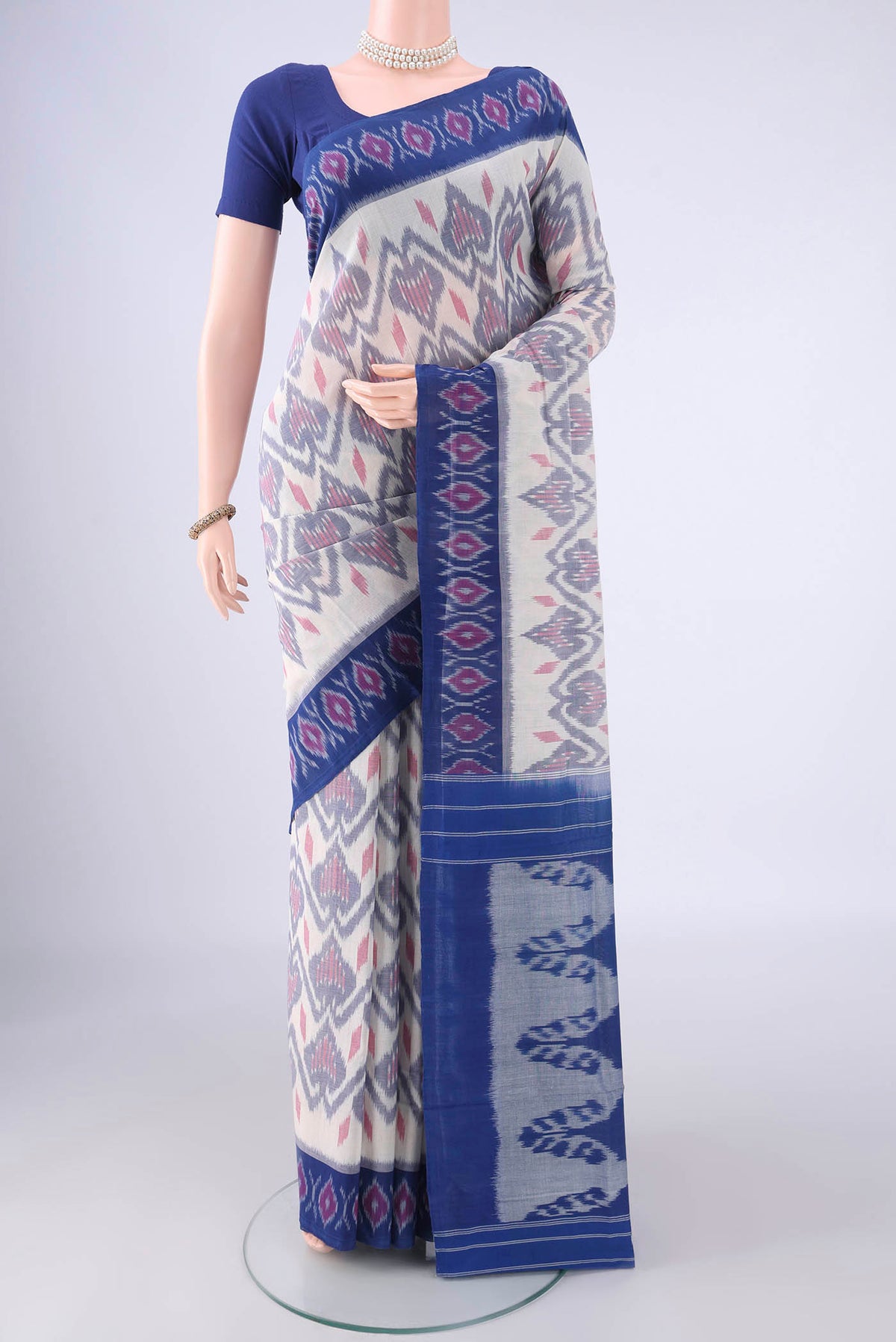 Off White Pochampally Cotton Saree with Ikat design on the body and Ikat Border.  displayed on a mannequin