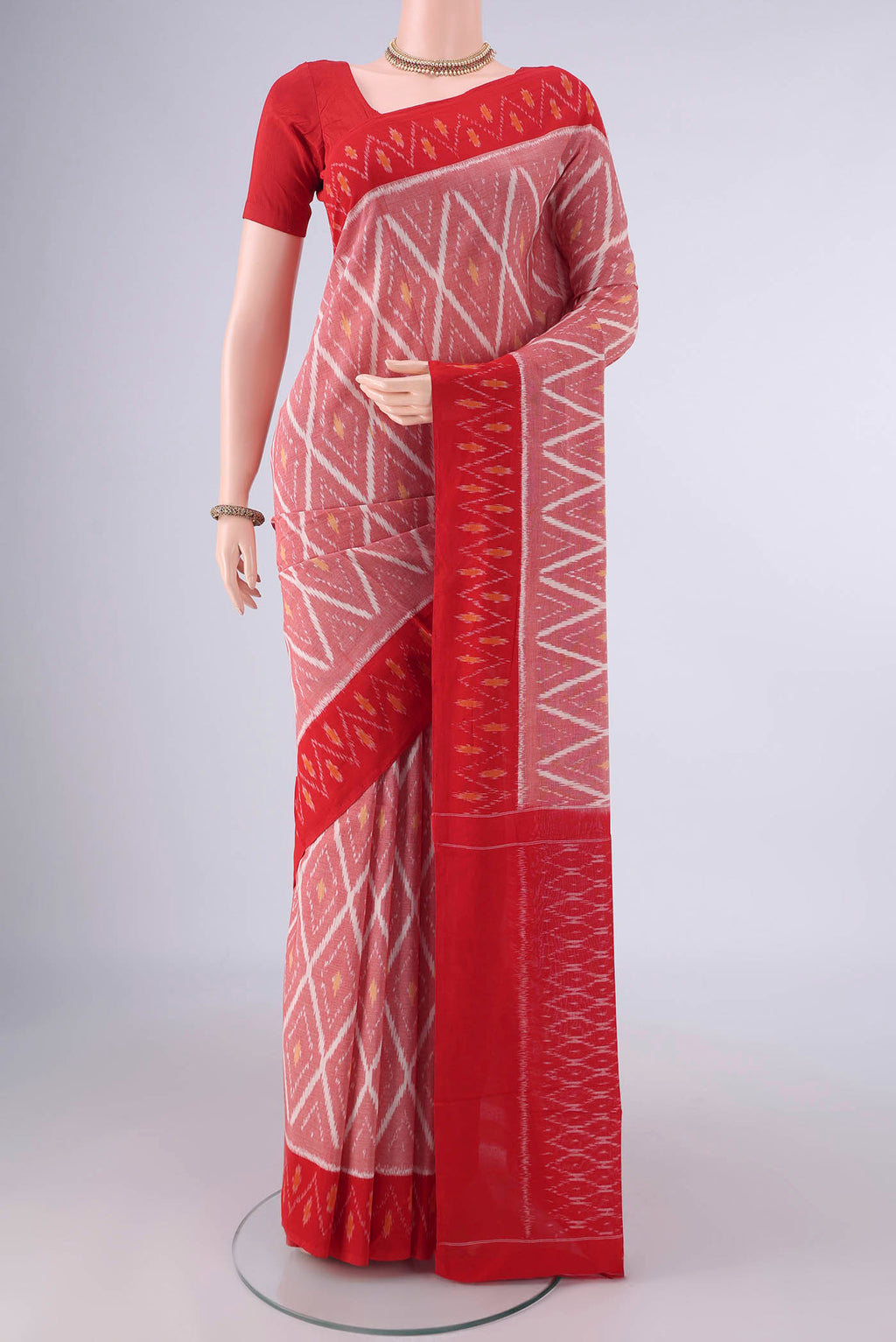 Peach Pochampally Cotton Saree with Ikat design on the body and Ikat Border.  displayed on a mannequin