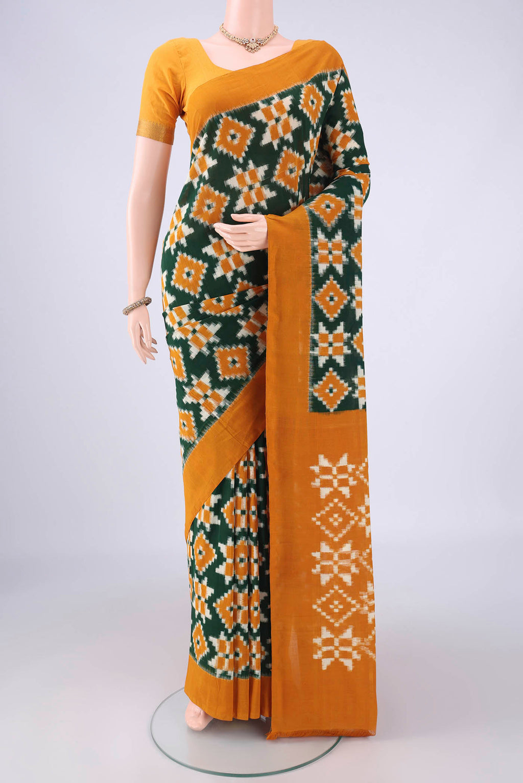 Bottle Green Pochampally Cotton Saree with Ikat design on the body and Plain Border.  displayed on a mannequin