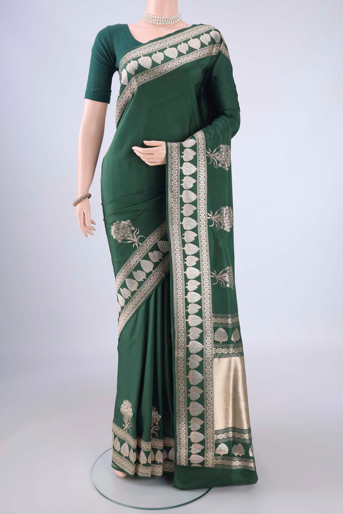 Bottle Green Banarasi Silk Saree with Zari Butta on the body and Zari Border.  displayed on a mannequin