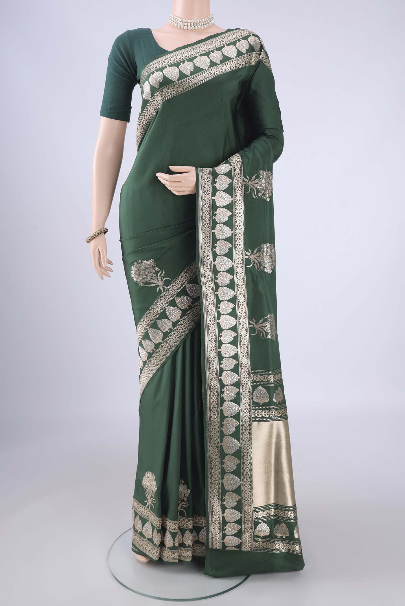 Bottle Green Banarasi Silk Saree with Zari Butta on the body and Zari Border.  displayed on a mannequin