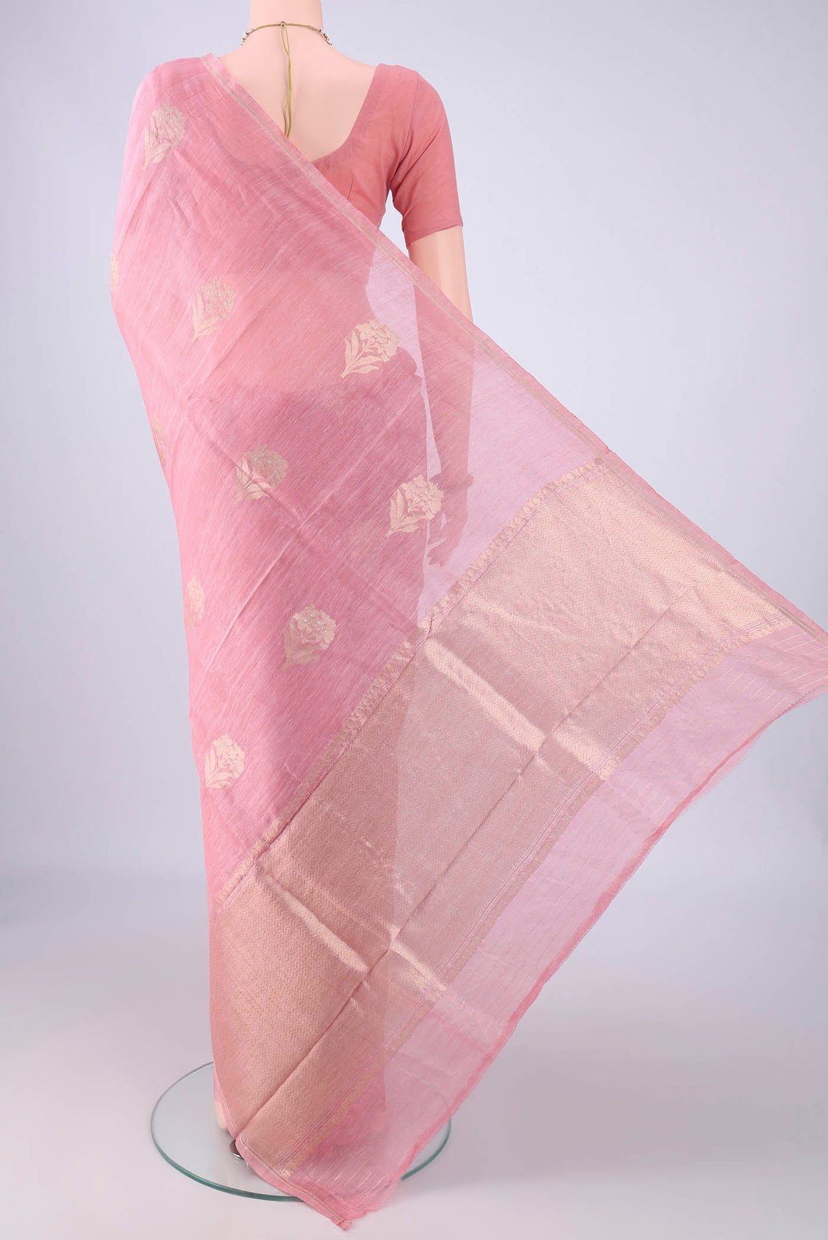 Flat view of Rose pink Linen Saree with Zari Butta on the body and Thin Zari Line. 
