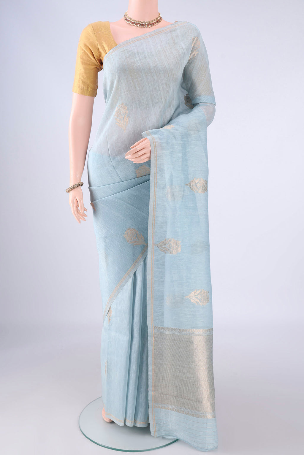 Sky Blue Linen Saree with Zari Butta on the body and Thin Zari Line.  displayed on a mannequin
