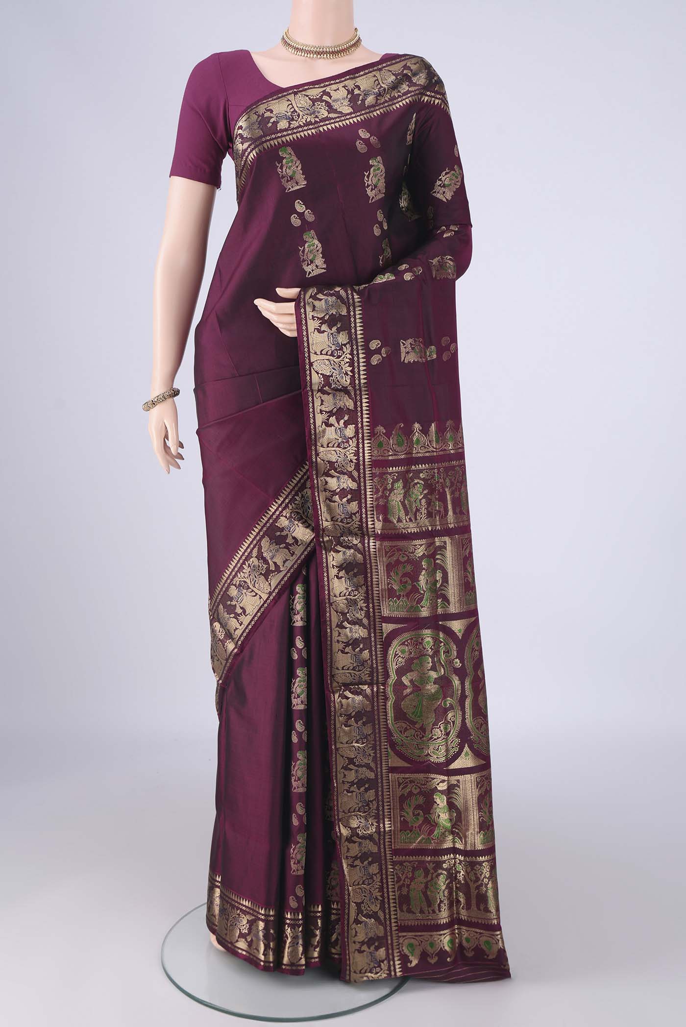Burgundy Baluchari Silk Saree with Zari And Thread Butta on the body and Zari Border.  displayed on a mannequin