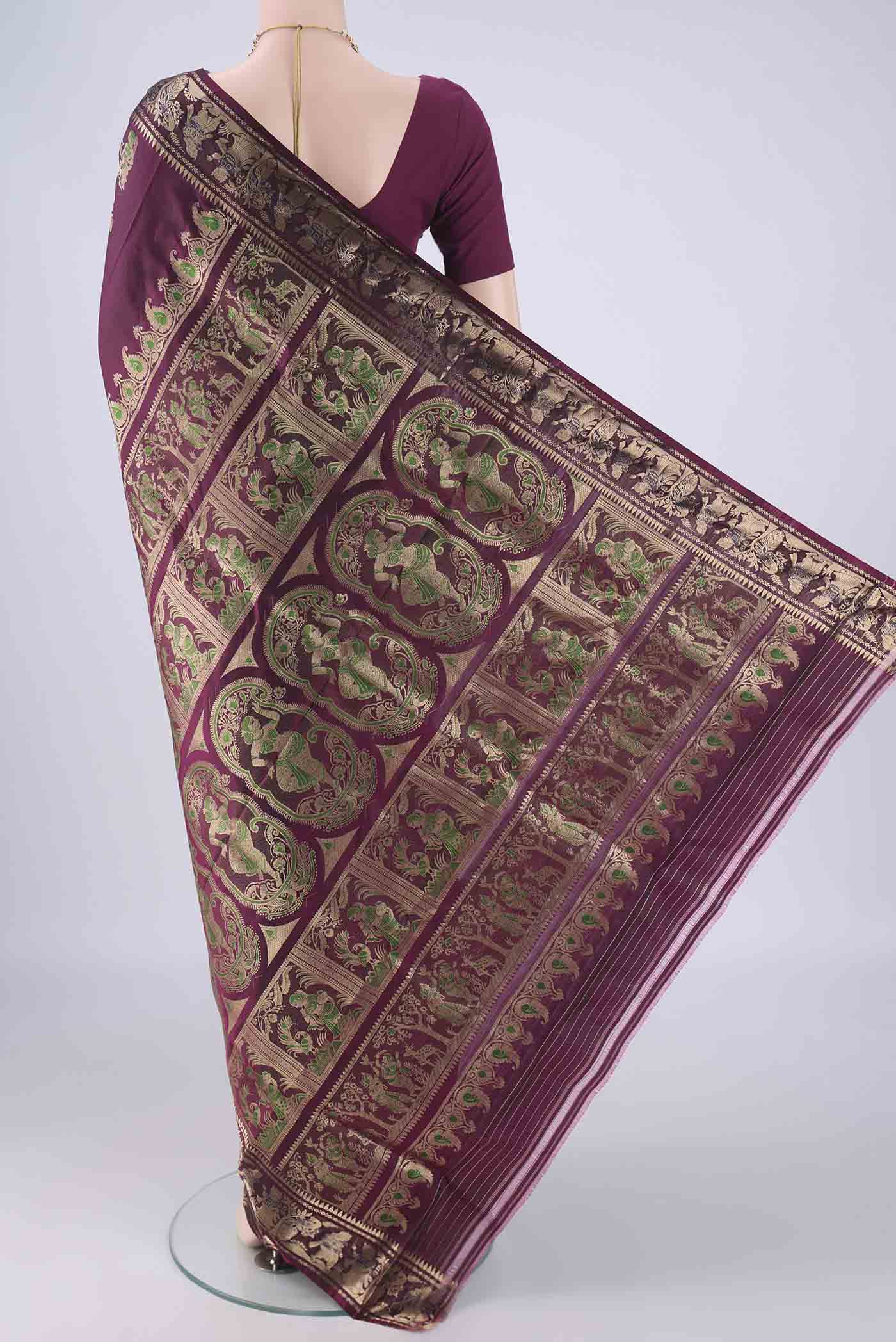 Flat view of Burgundy Baluchari Silk Saree with Zari And Thread Butta on the body and Zari Border. 